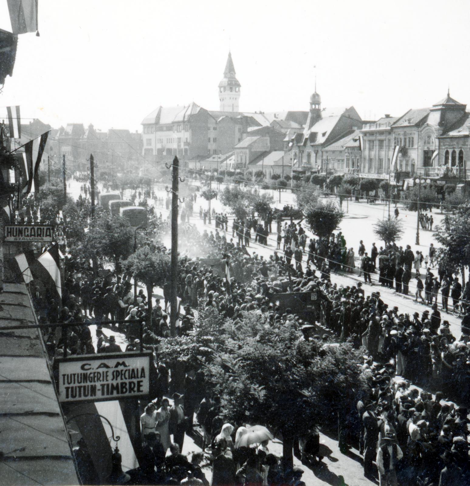 Románia,Erdély, Marosvásárhely, Rózsák tere (Piata Trandafirilor, ekkor Széchenyi tér), balra a háztetők felett a Városháza tornya látható. A felvétel a magyar csapatok bevonulása idején készült., 1940, Tordai György, zománctábla, Fortepan #233183