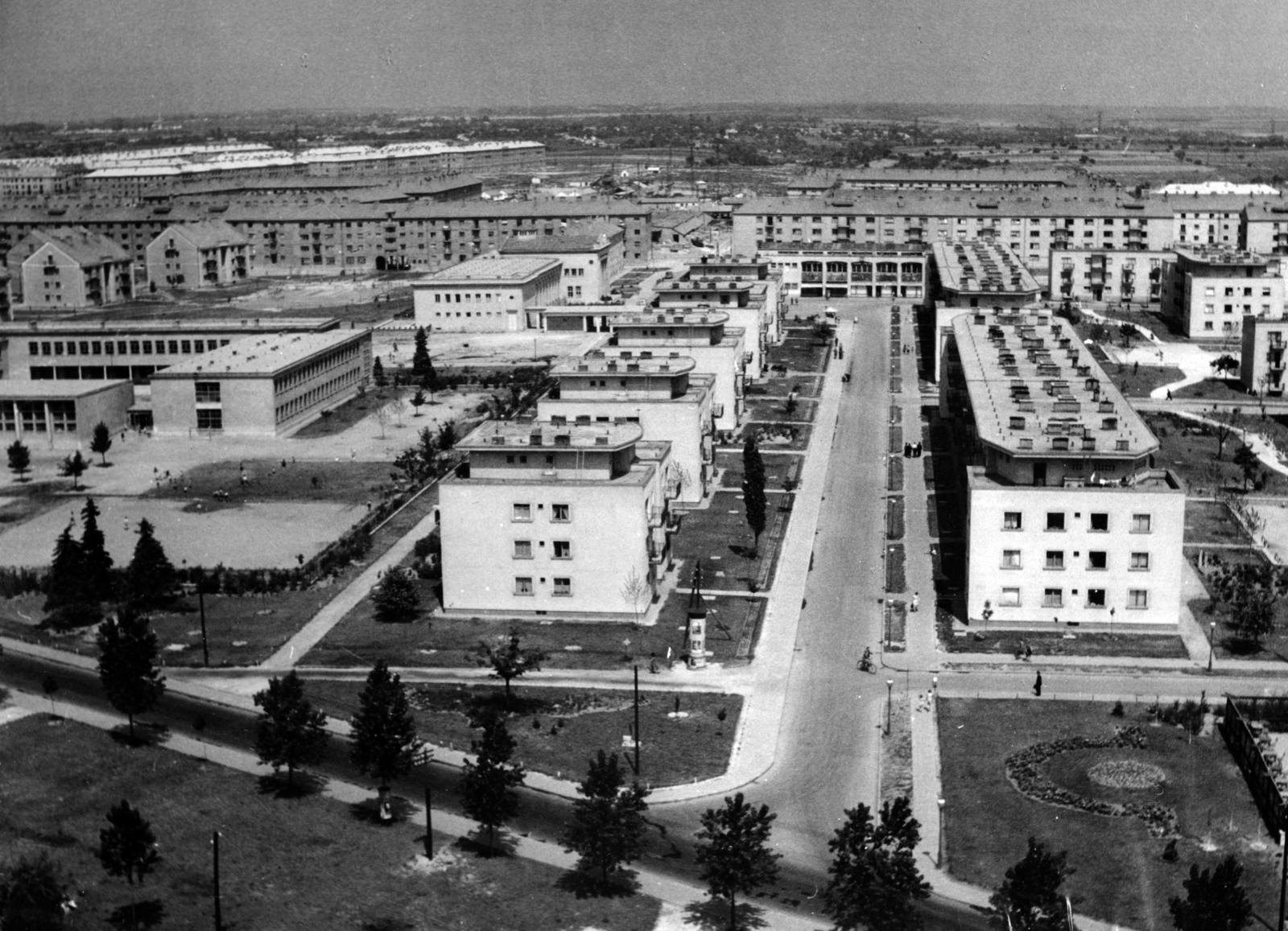 Hungary, Dunaújváros, (Sztálinváros), kilátás a Víztoronyból, szemben a Május 1. utca épületsora és a Béke Étterem és Üzletház. Balra a Vasvári Pál Általános Iskola épülettömbje és utána a Bartók Béla Kultúrház (később Bartók Kamaraszínház és Művészetek Háza) épülete. Előtérben az Építők útja melletti fasor látható., 1955, Hegyvidéki Helytörténeti Gyűjtemény, Fortepan #234299