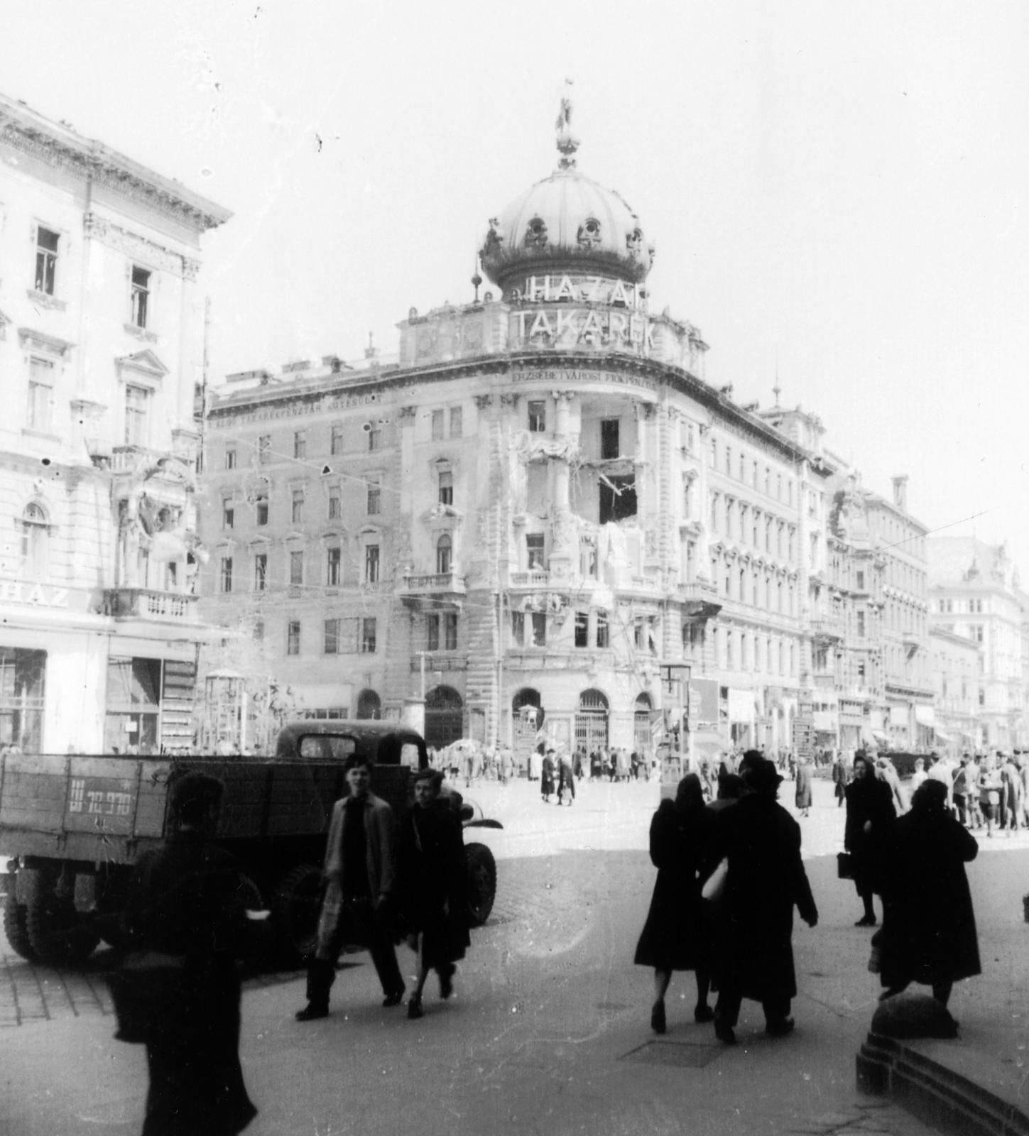 Magyarország, Budapest V.,Budapest VIII., Blaha Lujza tér, szemben a megrongálódott épület az Erzsébet körút - Rákóczi út sarkon áll., 1945, Kirilly Gergely, járókelő, útkereszteződés, Takarékpénztár, Budapest, Fortepan #235944