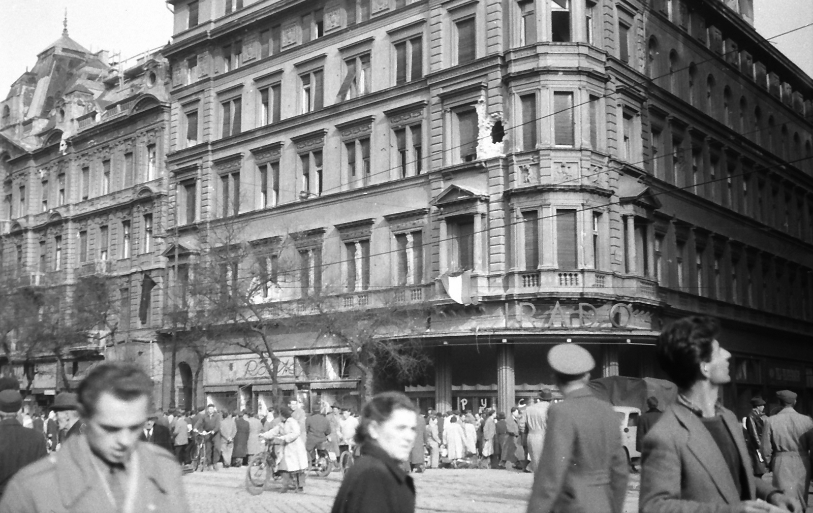 Hungary, Budapest VII., Erzsébet (Lenin) körút - Dohány utca sarok., 1956, Juricza Tibor, bicycle, flag, revolution, damaged building, movie theater, Röltex-brand, Budapest, Fortepan #23677