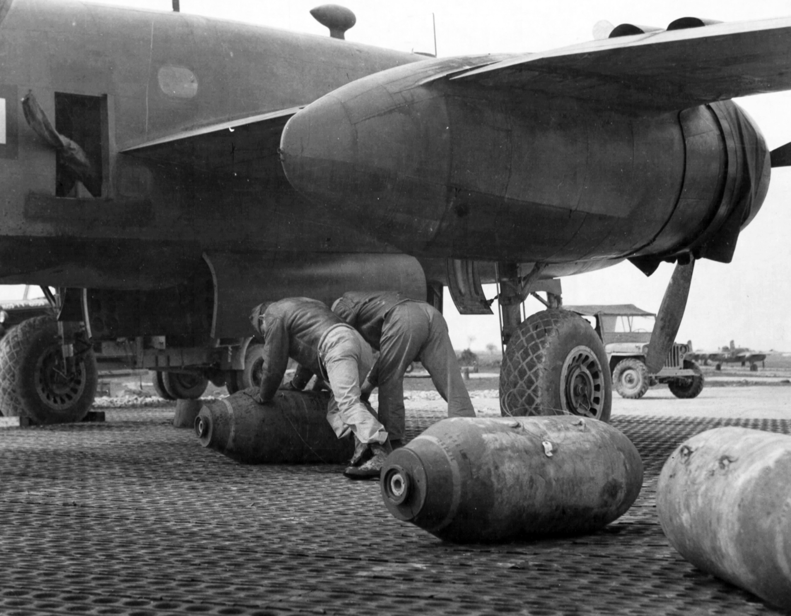 Az amerikai légierő B-25 Mitchell kétmotoros közepes bombázó repülőgépe. A gép előtt egy Willys Jeep áll a betonon., 1944, National Archives, közlekedés, amerikai gyártmány, bombázás, repülőgép, katonaság, vadászrepülő, második világháború, dzsip, repülőtér, USAAF, bomba, graffiti, North American-márka, North American B-25 Mitchell, Willys-márka, Willys Jeep, amerikai katona, Fortepan #24348