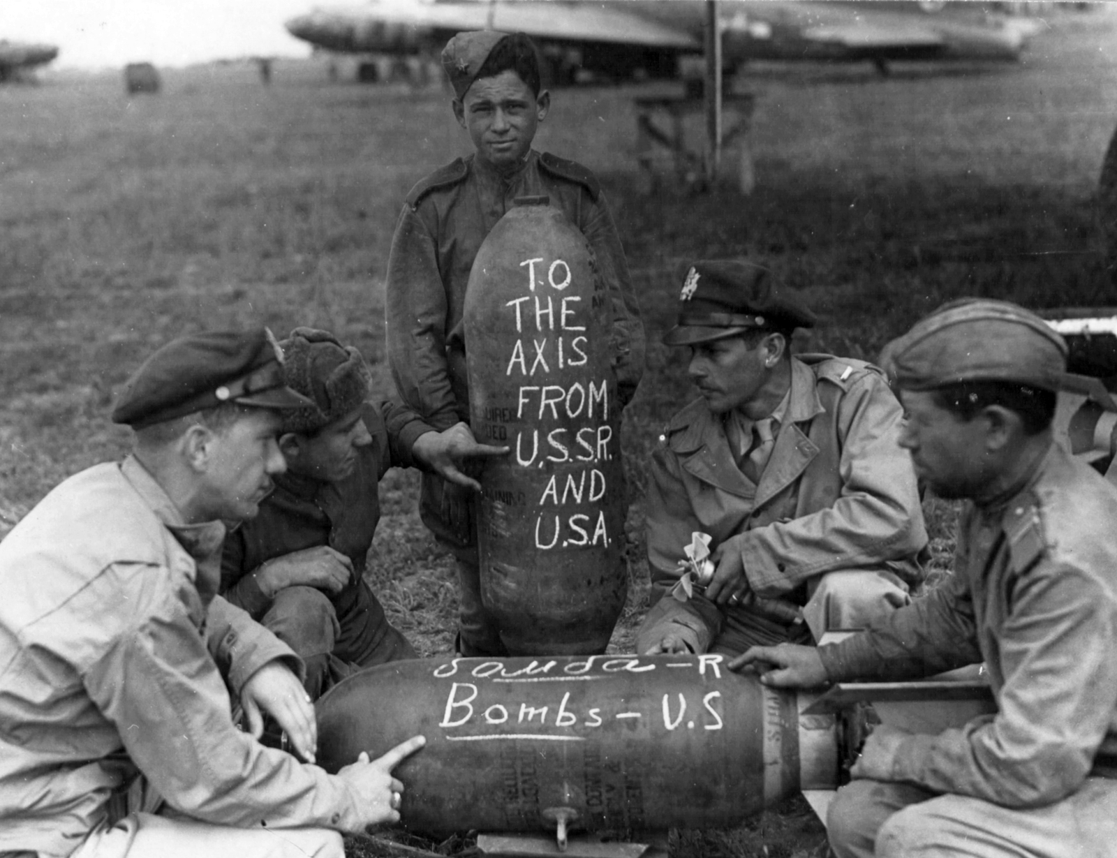 Ukrajna, Poltava, amerikai és orosz katonák 1944-ben a FRANTIC hadművelet idején. A háttérben egy B-17 Flying Fortress bombázógép és egy C-47 Dakota szállítógép látható., 1944, National Archives, Szovjetunió, keleti front, bombázás, második világháború, katona, repülőtér, szovjet katona, USAAF, bomba, amerikai katona, cirill írás, ködvágó sapka, Fortepan #24351