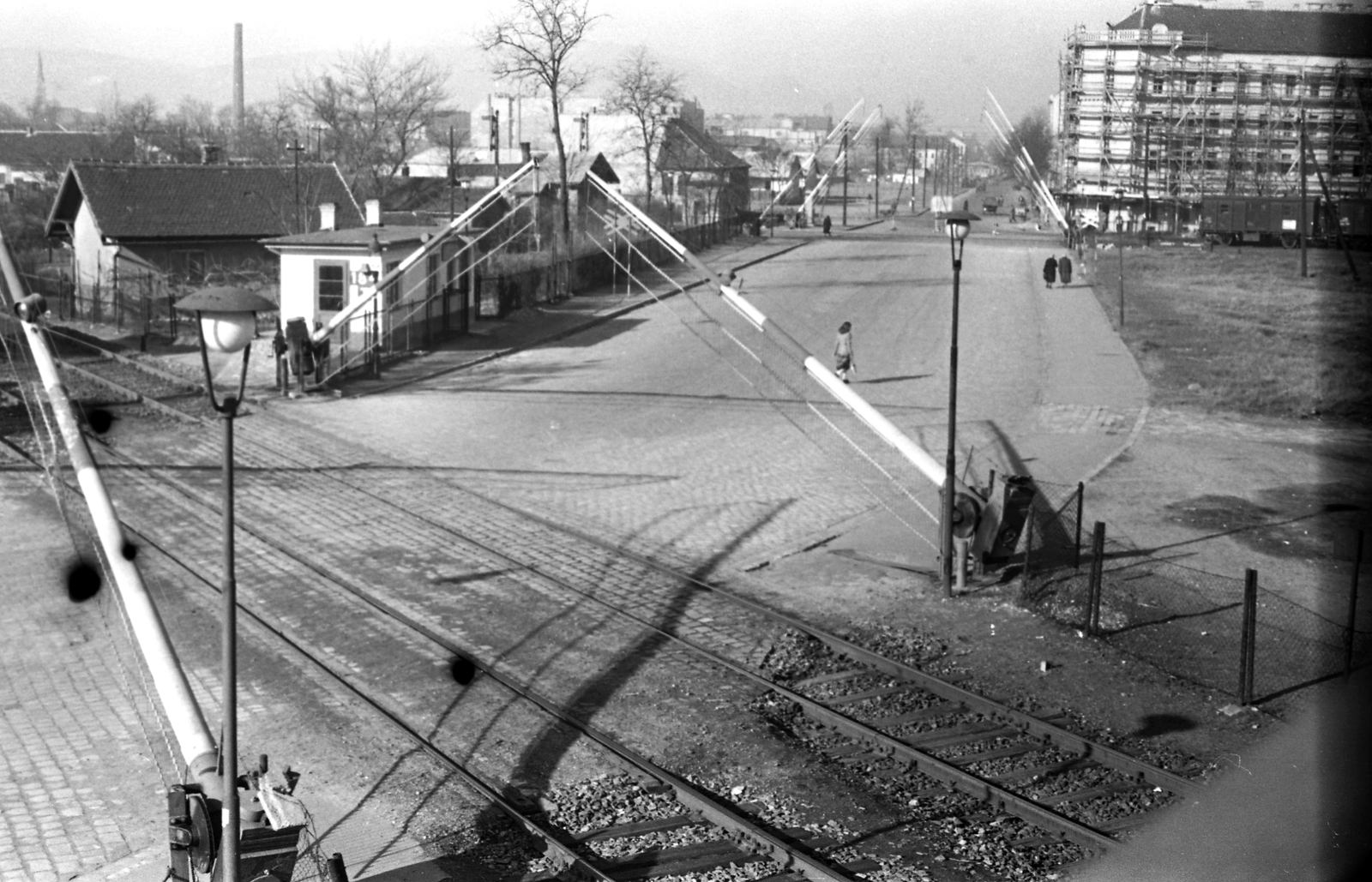 Hungary, Budapest XIV.,Budapest XIII., Hungária körút, szemben a Róbert Károly körút sarkán a Szent László út (Mautner Sándor utca) 2. számú ház látszik., 1954, FŐMTERV, barrier, rail, cobblestones, rails, public lighting, factory chimney, railroad crossing, Budapest, Fortepan #251012