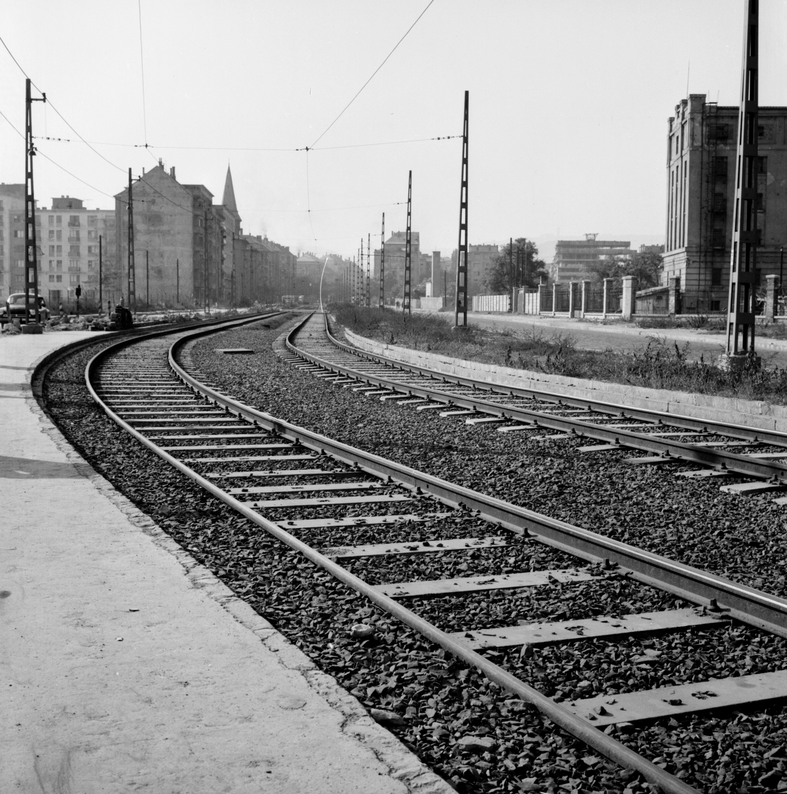 Hungary, Budapest XI., Október huszonharmadika (Schönherz Zoltán) utca a Budafoki úttól a Fehérvári út felé nézve. Balra a Kelenföldi református templom tornya, jobbra a Lágymányosi Dohánygyár látható., 1959, FŐMTERV, tobacco factory, Budapest, Fortepan #251164