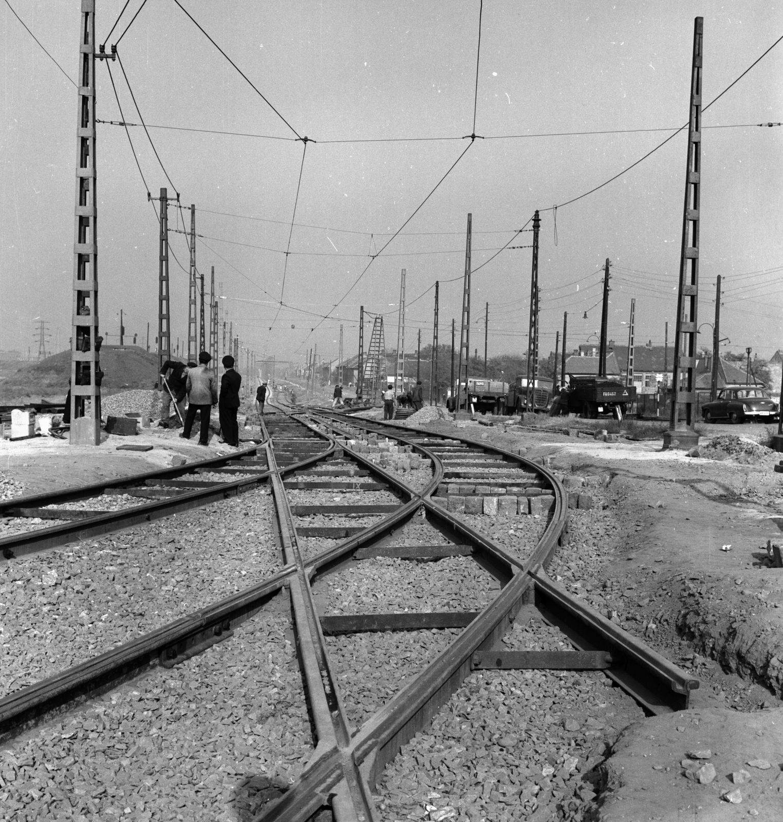 Hungary, Budapest IX.,Budapest XX., Határ út a Gubacsi út felőli sínpálya becsatlakozásánál. Kicsit távolabb a Török Flóris utcai leágazásnál szerelik a felsővezetéket., 1959, FŐMTERV, Budapest, pylon, construction, cobblestones, rails, Fortepan #251175