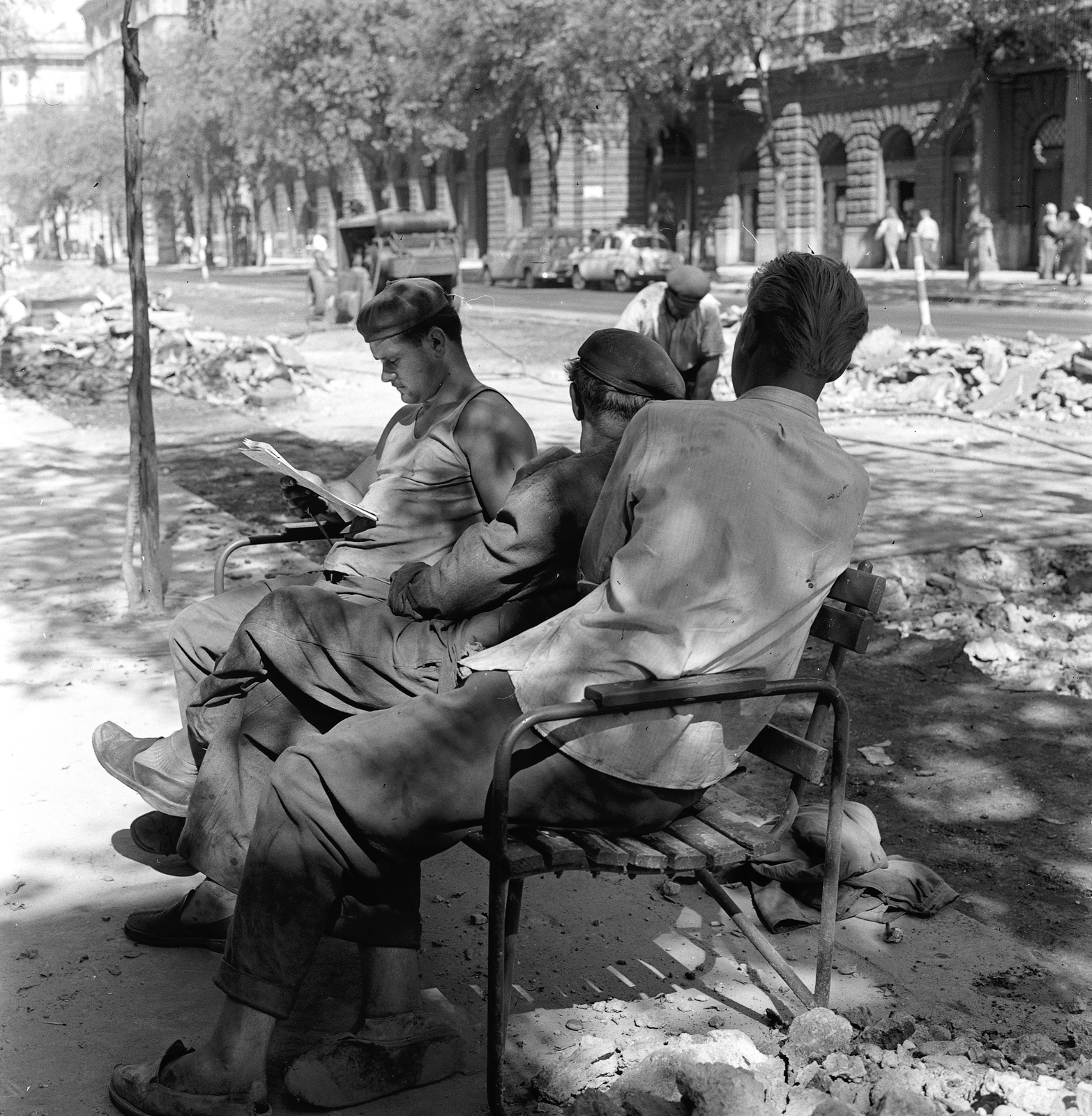 Magyarország, Budapest VI., Andrássy út (Népköztársaság útja), szemben középen a Székely Mihály (Kazár) utca. A felvétel az Andrássy út (Népköztársaság útja) Bajcsy-Zsilinszky út és az Oktogon (November 7. tér) közötti szakaszának 1960. nyarán történt átépítése során készült., 1960, FŐMTERV, Domonkos Endre, Budapest, pihenés, olvasás, pad, Fortepan #251336