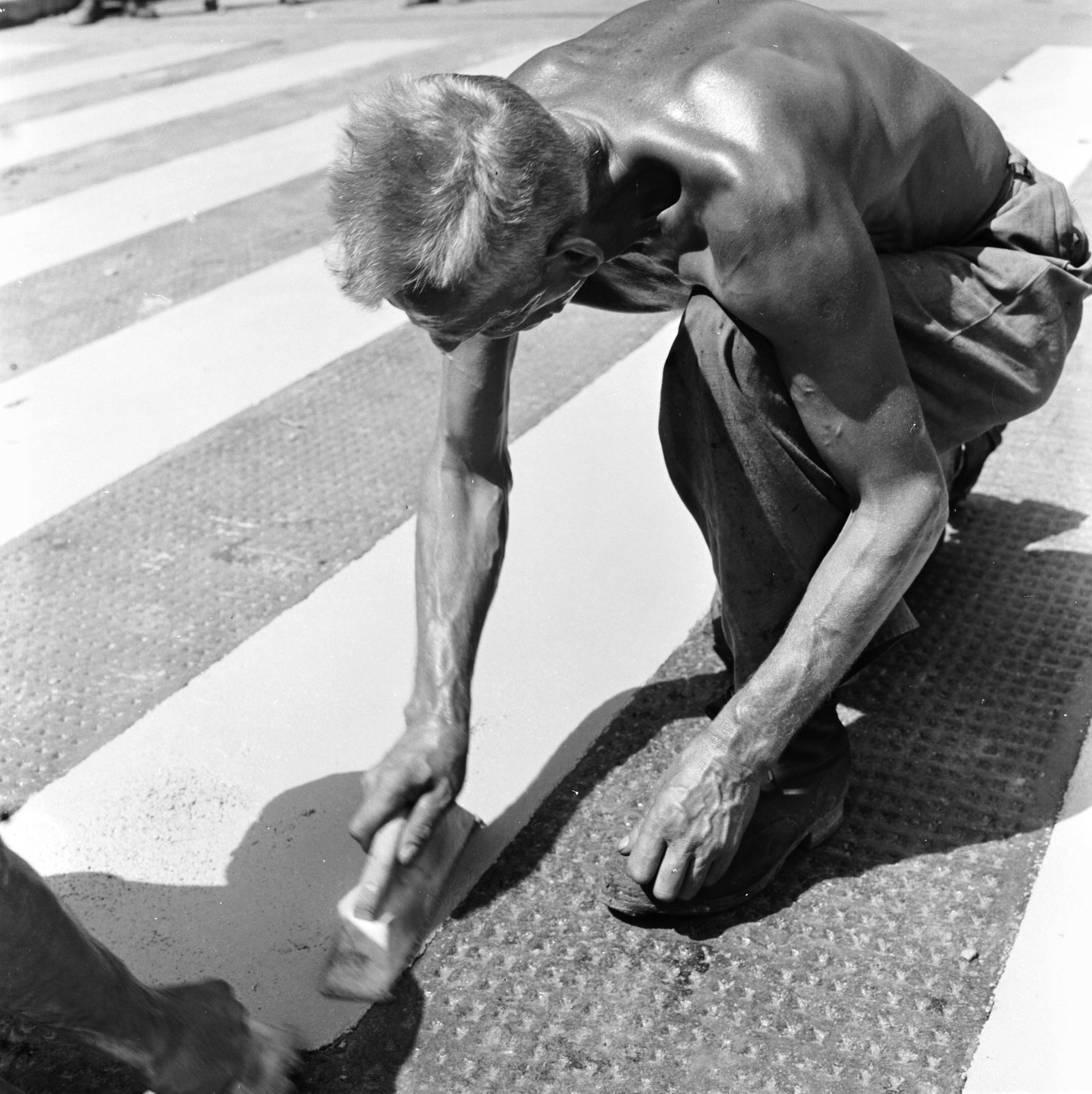 Magyarország, Budapest VI., gyalogátkelő az Andrássy út (Népköztársaság útja) és a Dalszínház utca kereszteződésében az Andrássy út (Népköztársaság útja) páros oldalán. A felvétel az Andrássy út (Népköztársaság útja) Bajcsy-Zsilinszky út és az Oktogon (November 7. tér) közötti szakaszának 1960. nyarán történt átépítése során készült., 1960, FŐMTERV, Domonkos Endre, Budapest, munkás, napbarnított, félmeztelen, szerszám, gyalogátkelő, útépítés, Fortepan #251347