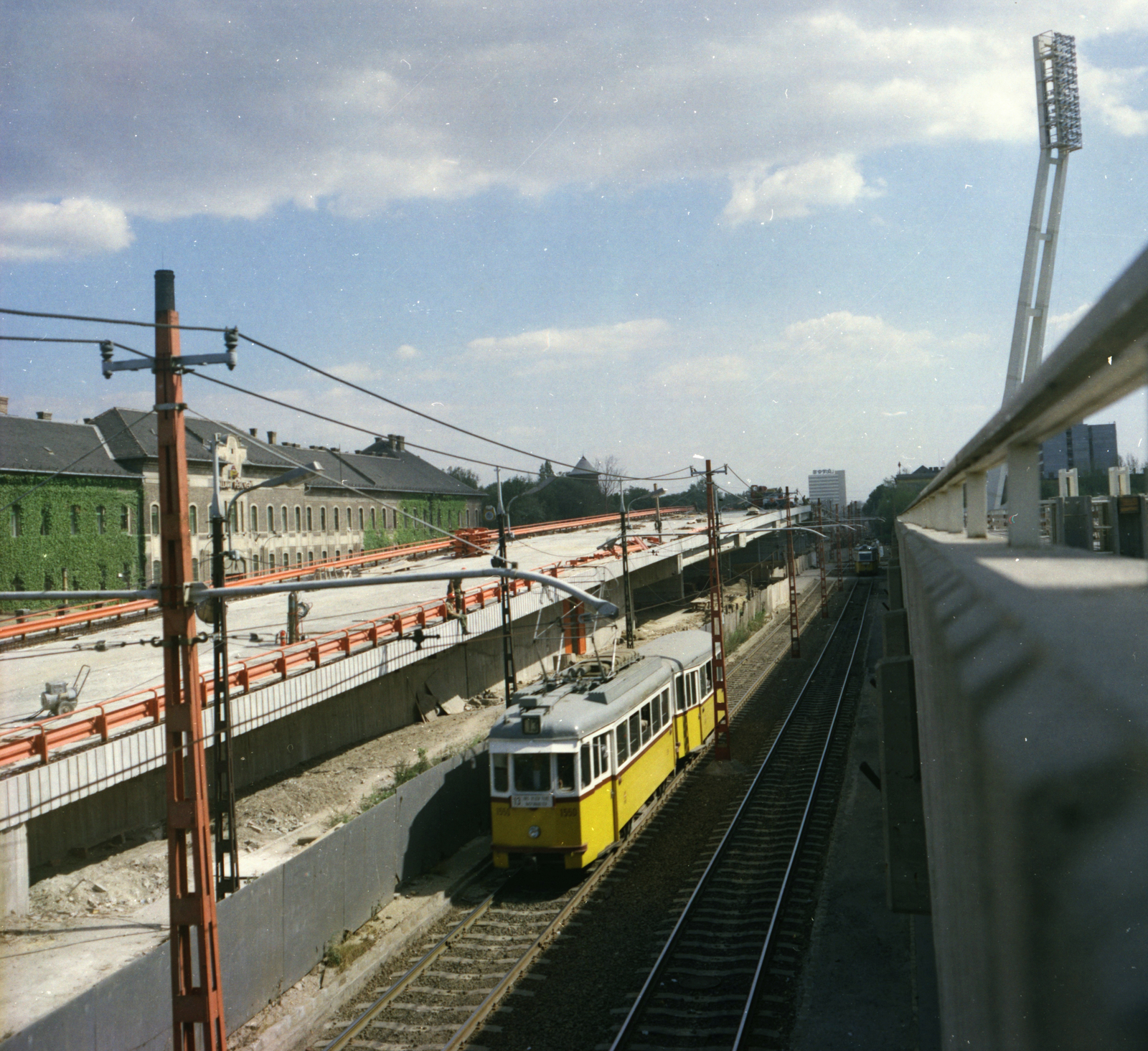 Magyarország, Budapest IX.,Budapest VIII., az épülő Üllői úti felüljáró a Könyves Kálmán körút felett. Balra az Állami Pénzverő épülete, jobbra az FTC stadionja., 1978, FŐMTERV, Domonkos Endre, színes, villamos, Budapest, Fortepan #253816