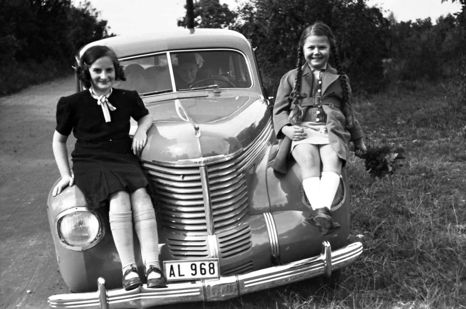 Opel Kapitän típusú személygépkocsi., 1940, Fortepan, German brand, Opel-brand, braid, bouquet, automobile, number plate, pantyhose, girls'n'cars, sitting on a car, Fortepan #25450