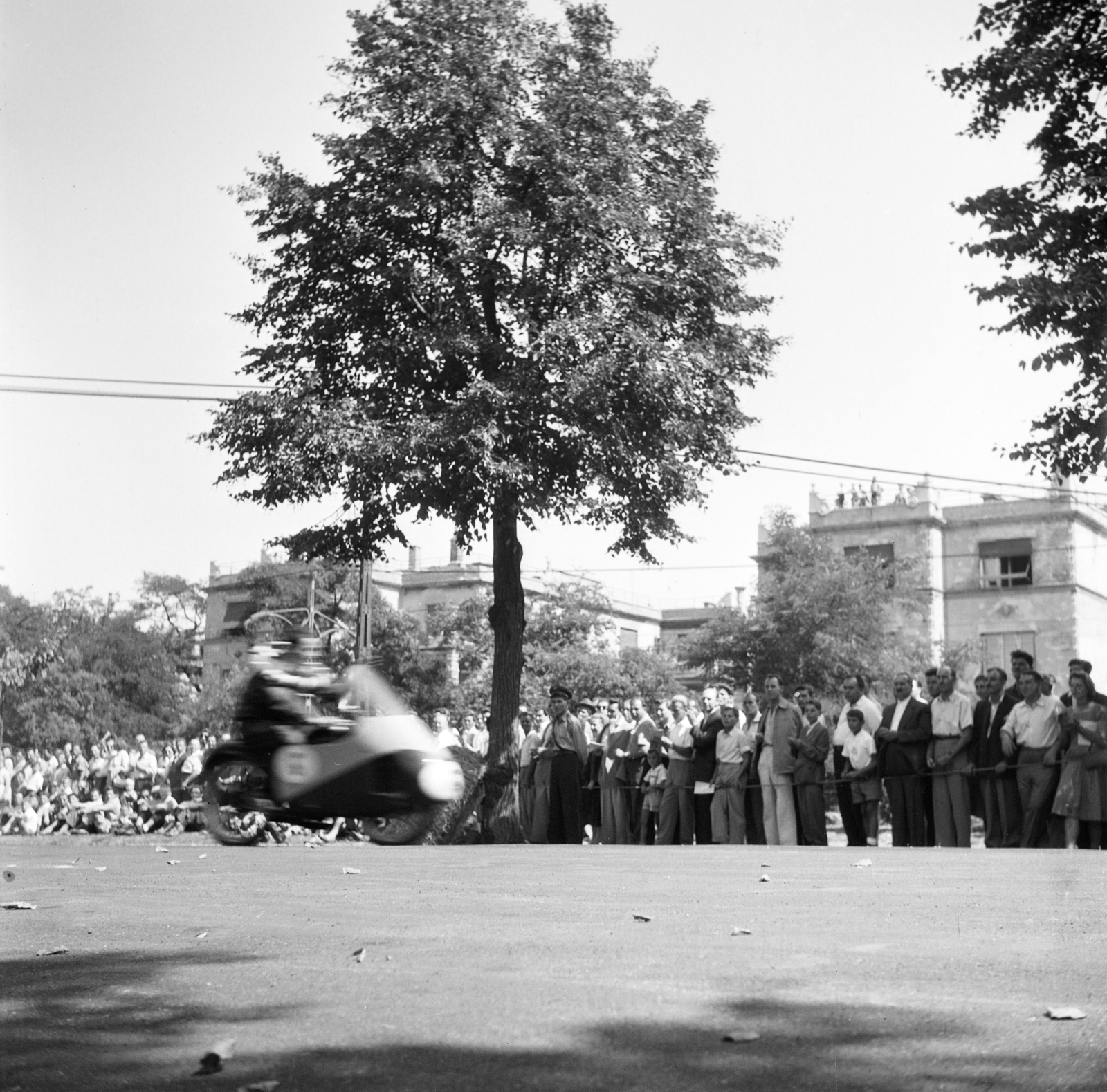 Magyarország, Városliget, Budapest XIV., motorverseny, háttérben a Hermina (Május 1.) út 35. és 37. számú épület látható., 1955, Ungváry Rudolf, Budapest, képarány: négyzetes, közönség, motorverseny, Fortepan #254957