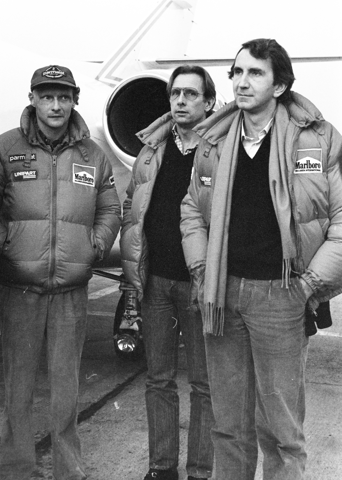 Magyarország, Ferihegyi (ma Liszt Ferenc) repülőtér, Budapest XVIII., balra Niki Lauda, jobbra John Watson, közöttük a Marlboro-cég motorsport-részlegének vezetője., 1982, Bojár Sándor, Budapest, autóverseny, híres ember, Fortepan #255359