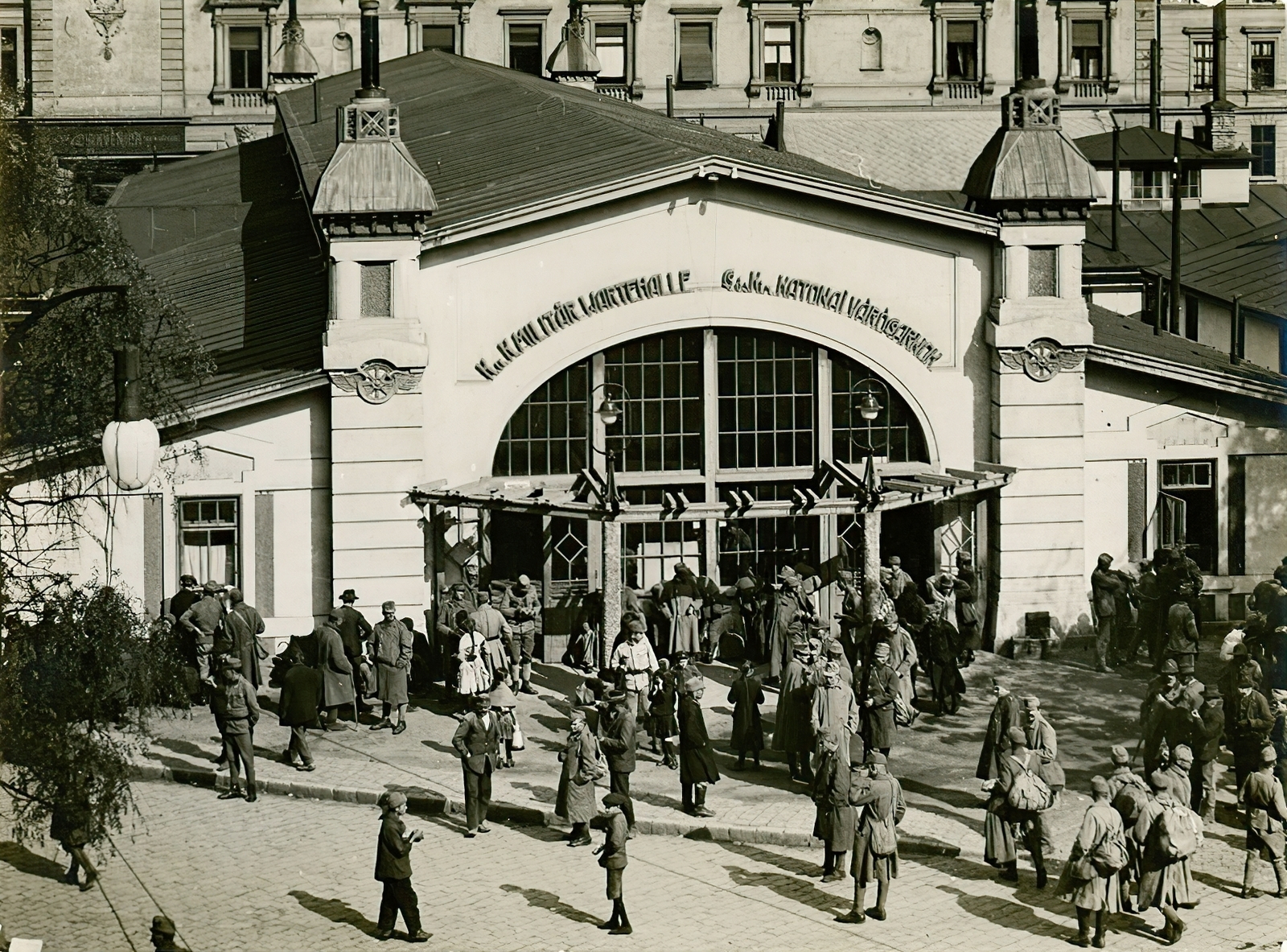 Magyarország, Budapest VIII.,Budapest VII., Baross tér, katonai várócsarnok a Keleti pályaudvarnál. Háttérben a Thököly út 3. számú ház Verseny utcai homlokzata., 1915, Országos Széchényi Könyvtár, Müllner János, Budapest, katona, felirat, várakozás, csoportosulás, német szöveg, embléma, hátizsák, pályaudvar, Fortepan #256048