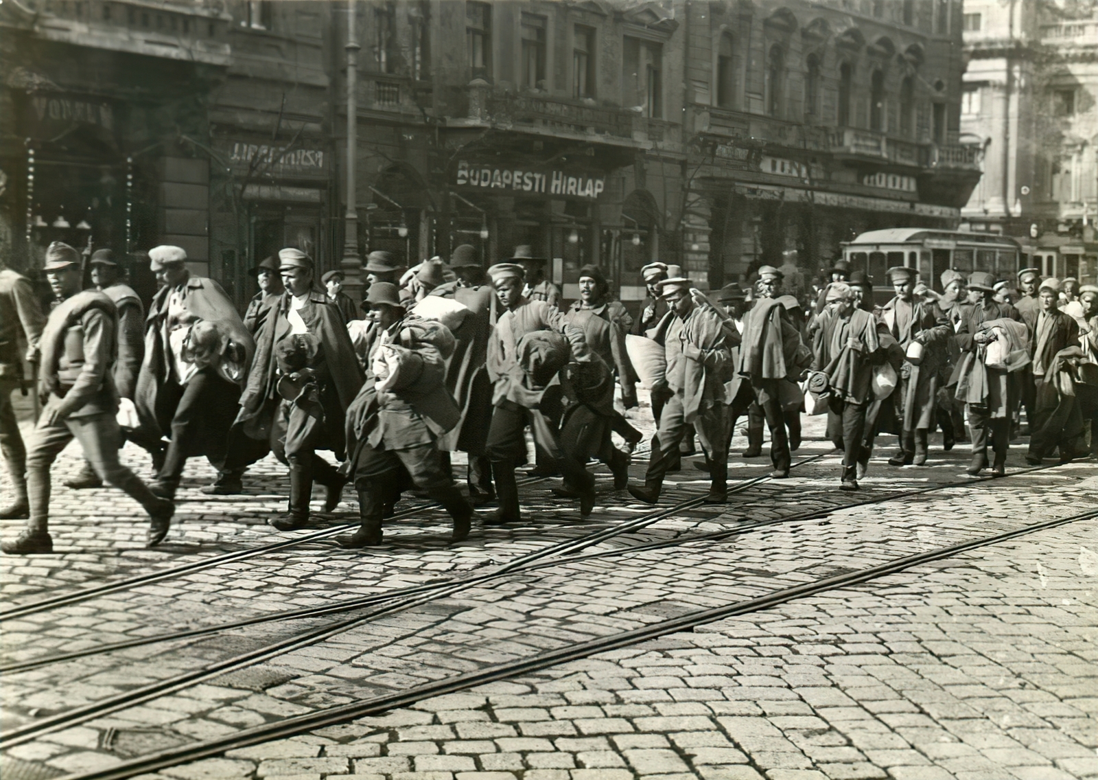 Magyarország, Budapest VIII., József körút, orosz hadifoglyok, háttérben a Nemzeti Színház épülete a Blaha Lujza téren., 1915, Országos Széchényi Könyvtár, Müllner János, villamos, kockakő, szovjet katona, Budapesti Hírlap, menetoszlop, hadifogoly, Budapest, Fortepan #256133
