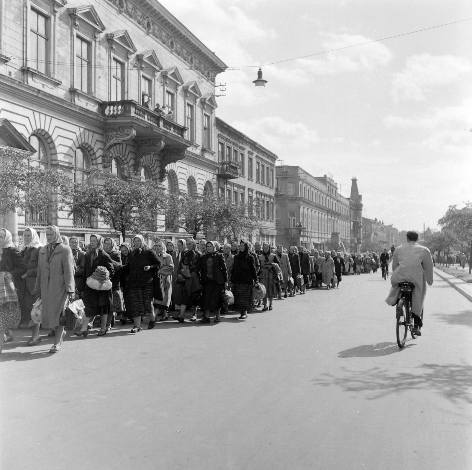 Poland, Częstochowa, ulica Marszalka Józefa Pilsudskiego, a kép bal szélén az 5. számú épület, ettől kissé távolabb az ulica Katedralna torkolata., 1956, Peter, Isaac, revolution, march, photo aspect ratio: square, headscarf, women, carrying, packet, Fortepan #256839