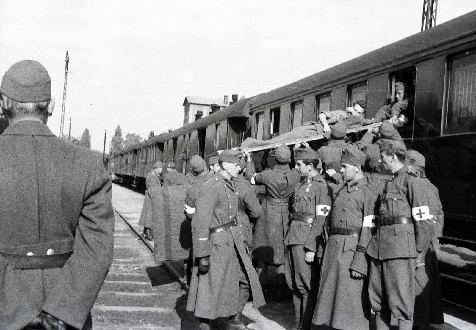 Hungary, Kecskemét, vasútállomás, a 154-es számú vöröskeresztes kórházvonatból hordágyon emelik ki a sebesült katonát., 1942, Reményi József, hospital-train, Fortepan #257589