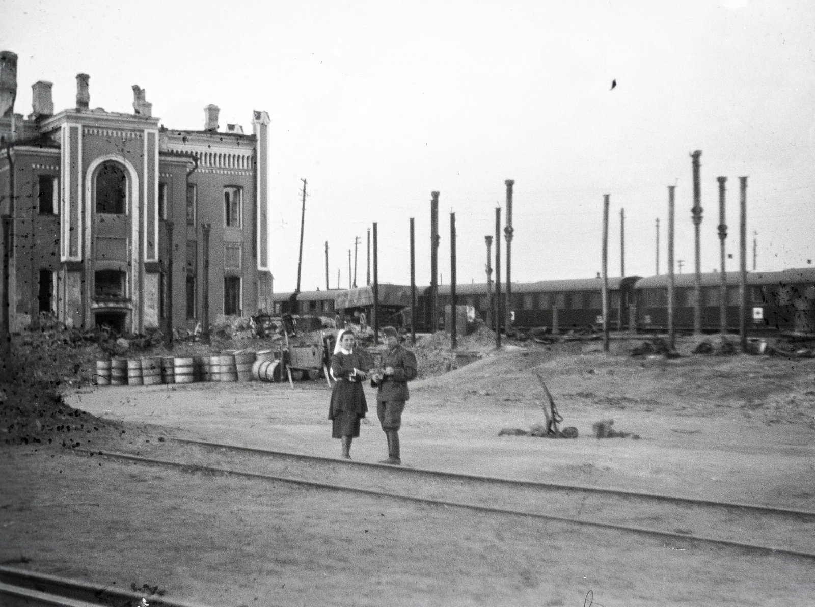 Oroszország, Kurszk, a vöröskeresztes kórházvonat nővére és tisztje a vasútállomáson., 1942, Reményi József, épületkár, háborús kár, hordó, Fortepan #257709