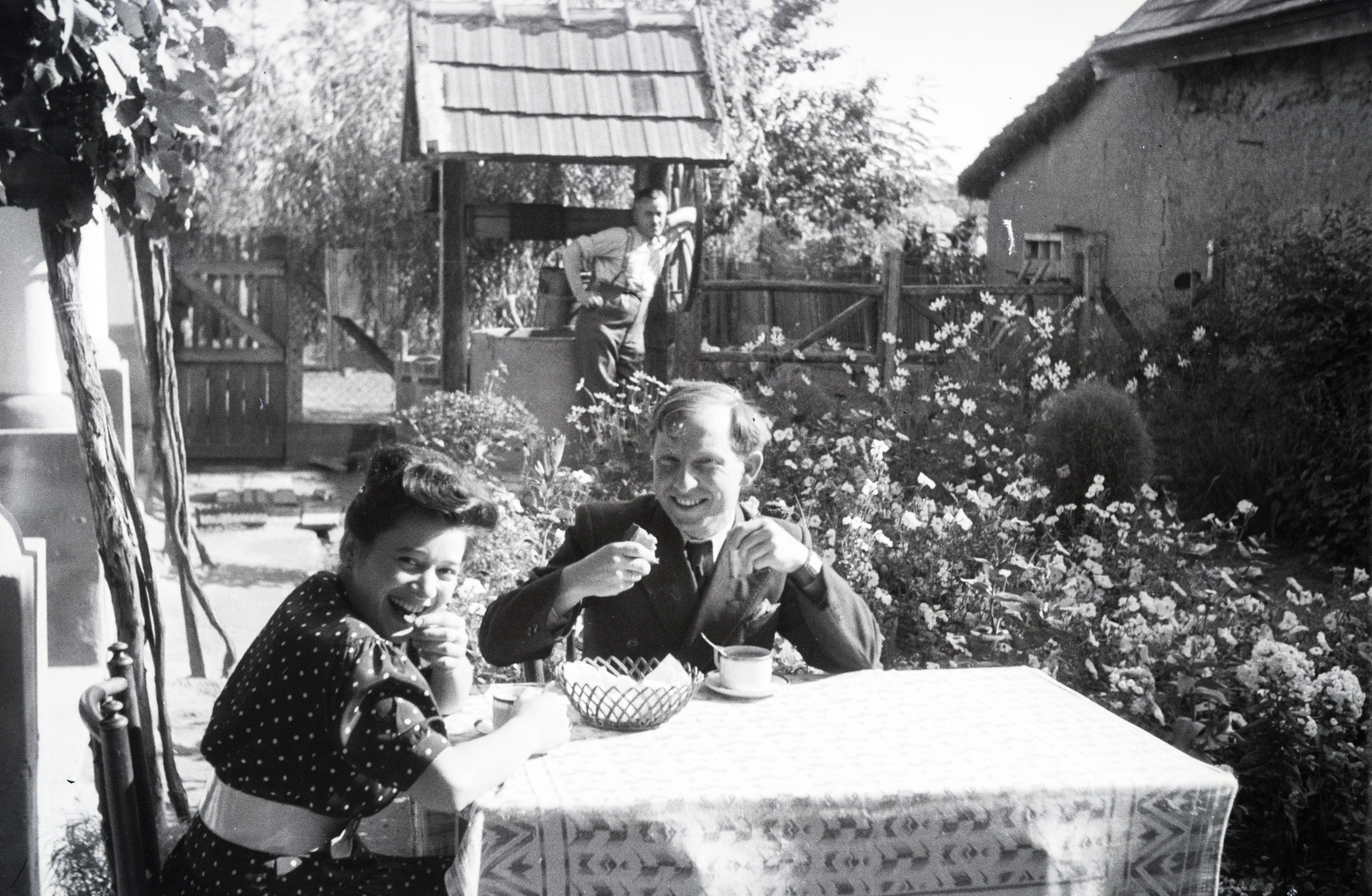 1942, Reményi József, kert, virágágyás, pöttyös ruha, étkezés, visszanézés, hárman, kerekeskút, Fortepan #257765