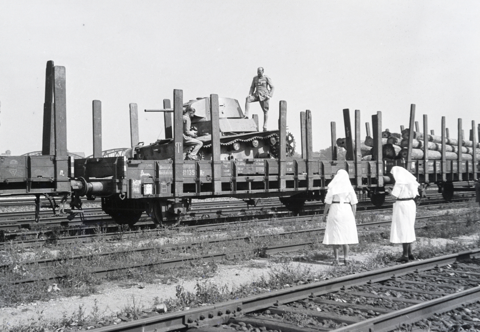 Poland, Toruń, rendező pályaudvar, a tehervagonon egy T–26 típusú szovjet könnyű harckocsi roncsa, balra a vagon felett a háttérben a Visztula folyó feletti Józef Piłsudski híd (Most im. marsz. Józefa Piłsudskiego) híd egy részlete látható., 1942, Reményi József, nurse, tank, Fortepan #257785