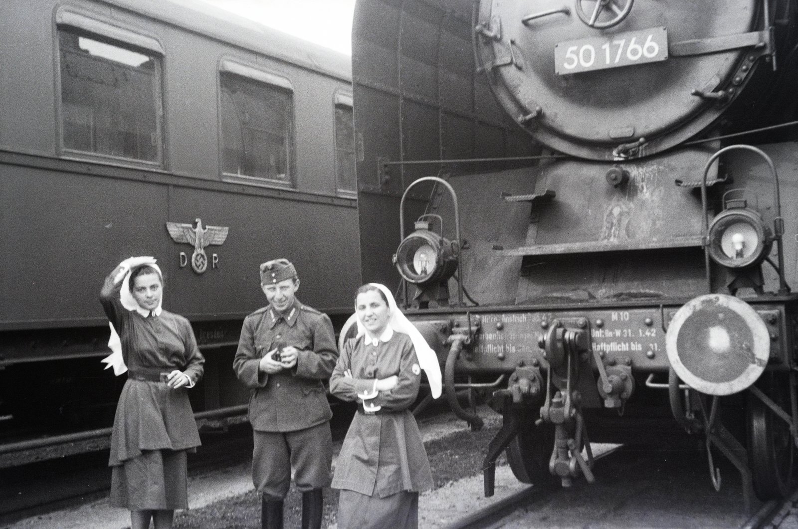 Poland, Warsaw, a 154-es számú vöröskeresztes kórházvonat önkéntes nővérei és a katonai személyzet egyik tagja. Háttérben egy német kórházvonat szerelvénye., 1942, Reményi József, swastica, DR/DB 50 series, steam locomotive, Fortepan #257871