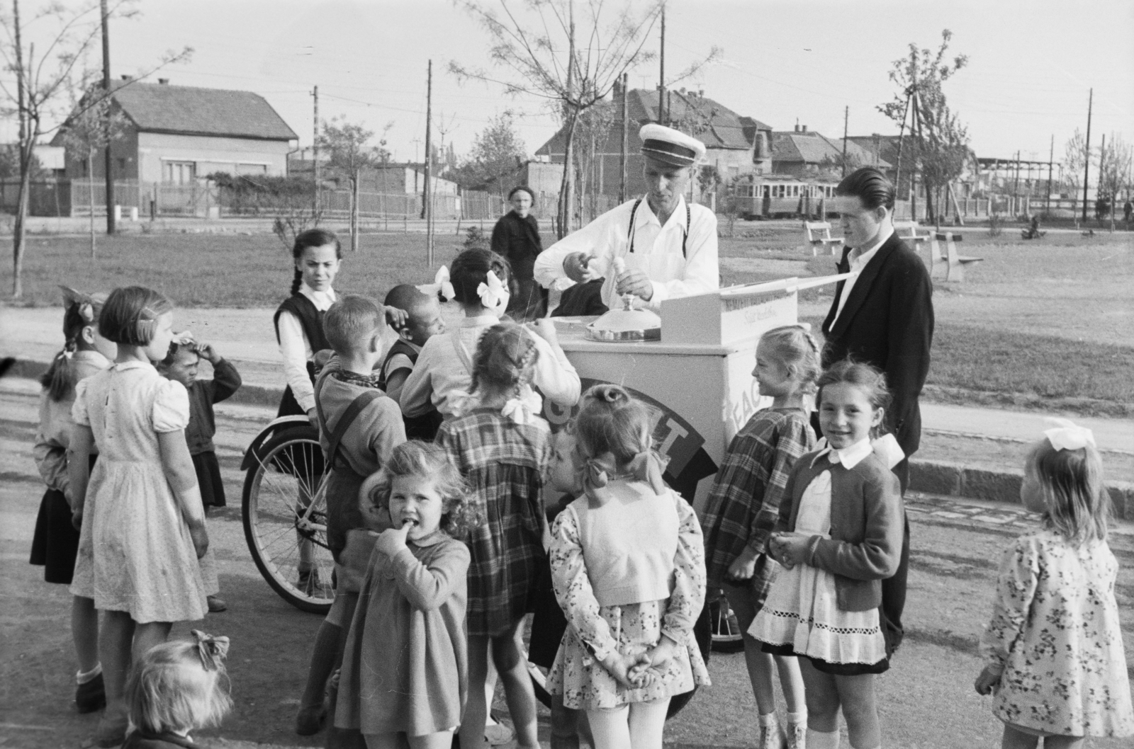 Hungary, Budapest XIII., Gyermek tér, háttérben a Béke utca Dolmány utca - Rokolya utca közötti szakasza., 1955, Reményi József, Best of, Budapest, ice cream seller, kids, peaked cap, twins, tricycle, tram, Fortepan #258693