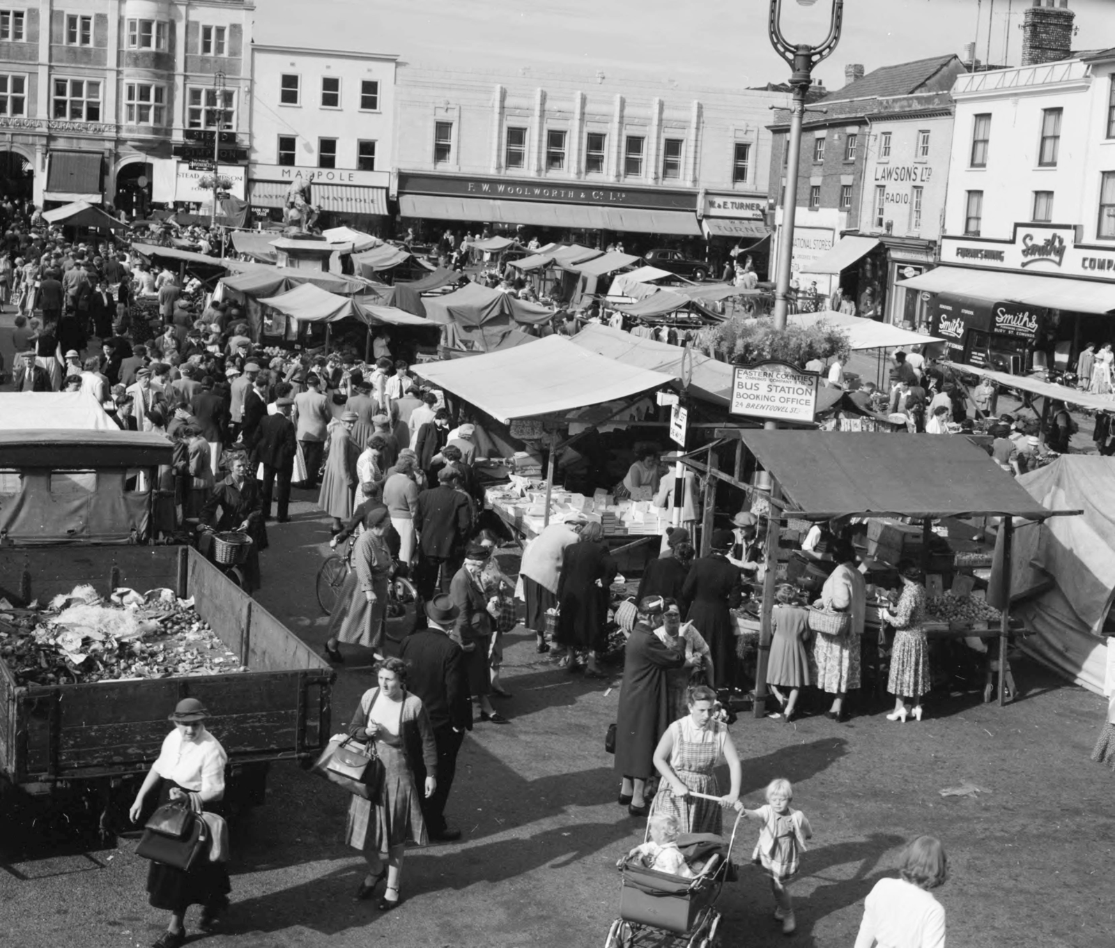 United Kingdom, Market Square, a tér közepén a búr háborúban elesett suffolki katonák emlékműve., 1956, UWM Libraries, English sign, awning, market, baby carriage, Fortepan #258824