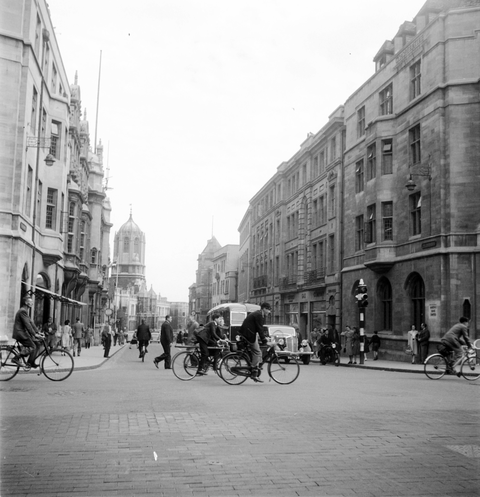 Egyesült Királyság, Oxford, balra a High Street, szemben a St Aldate's, jobbra a Queen Street. A távolban a Christ Church College és a Tom Tower., 1948, UWM Libraries, Robert Larimore Pendleton, kerékpár, utcakép, útkereszteződés, Fortepan #258898