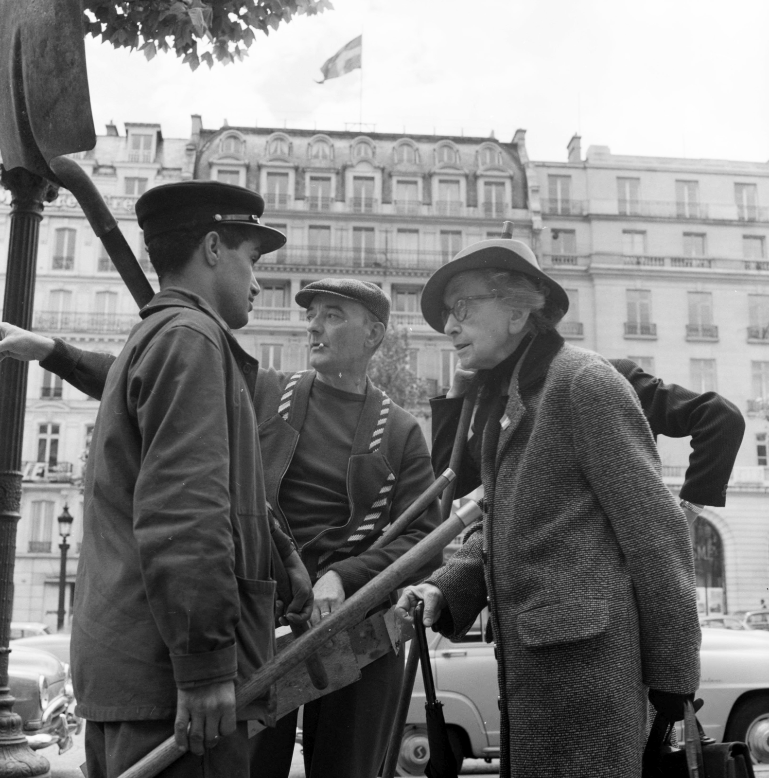 France, Paris, az Avenue des Champs-Élysées, a háttérben középen a 125. szám., 1958, UWM Libraries, Best of, photo aspect ratio: square, lady, shovel, old person, point a finger, hat, Fortepan #259222