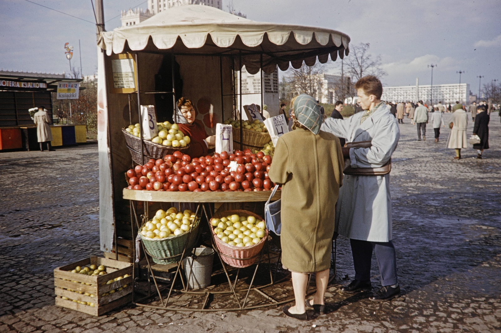 Lengyelország, Varsó, plac Defilad (Felvonulás tér), a gyümölcsárus asszony sátra mögött a Kultúra és Tudomány Palotája látszik., 1960, UWM Libraries, Harrison Forman, Best of, piac, gyümölcs, gyümölcsárus, színes, pavilon, Fortepan #260337