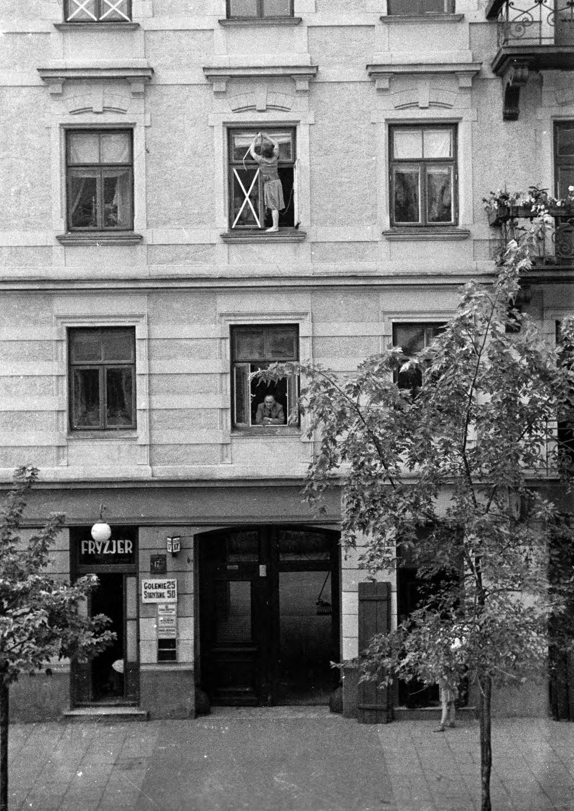 Lengyelország, Varsó, ulica Zielna 17. számú ház. A középen látható hölgy ragasztószalaggal próbál védekezni, a szétrepülő ablaküvegszilánk ellen., 1939, UWM Libraries, Harrison Forman, Best of, fodrászat, mutatvány, ablakmosás, Fortepan #260385