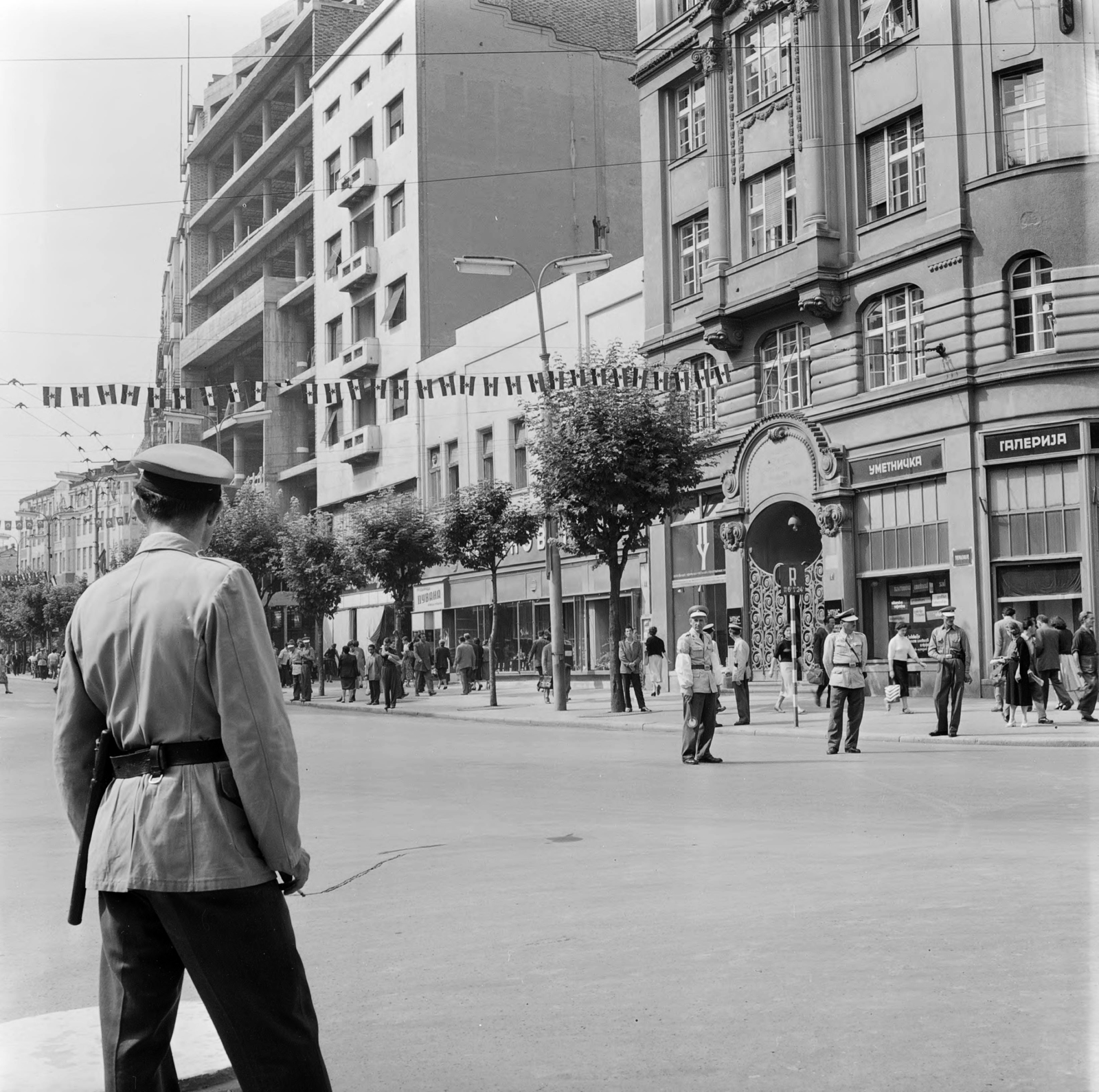 Serbia, Belgrade, a Kolarčeva és Sremska találkozásánál jobbra a Garni Hotel Evropa., 1955, UWM Libraries, street view, photo aspect ratio: square, pedestrian, directing traffic, Cyrillic alphabet, cop, Fortepan #260567