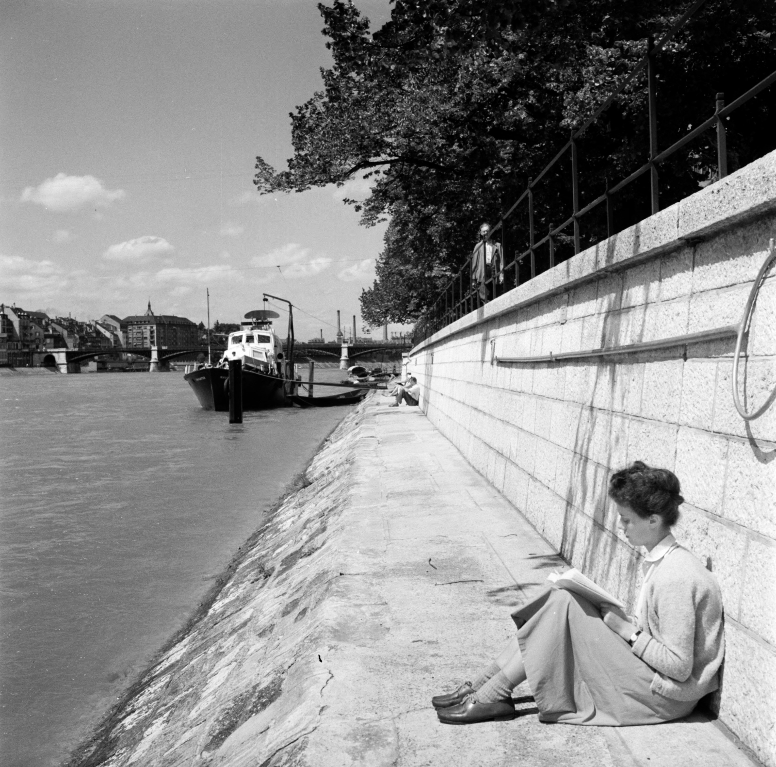 Switzerland, Basel, Rajna-part, a hajó mögött a Johanniterbrücke., 1958, UWM Libraries, photo aspect ratio: square, reading, sitting on the ground, shore, Fortepan #260675