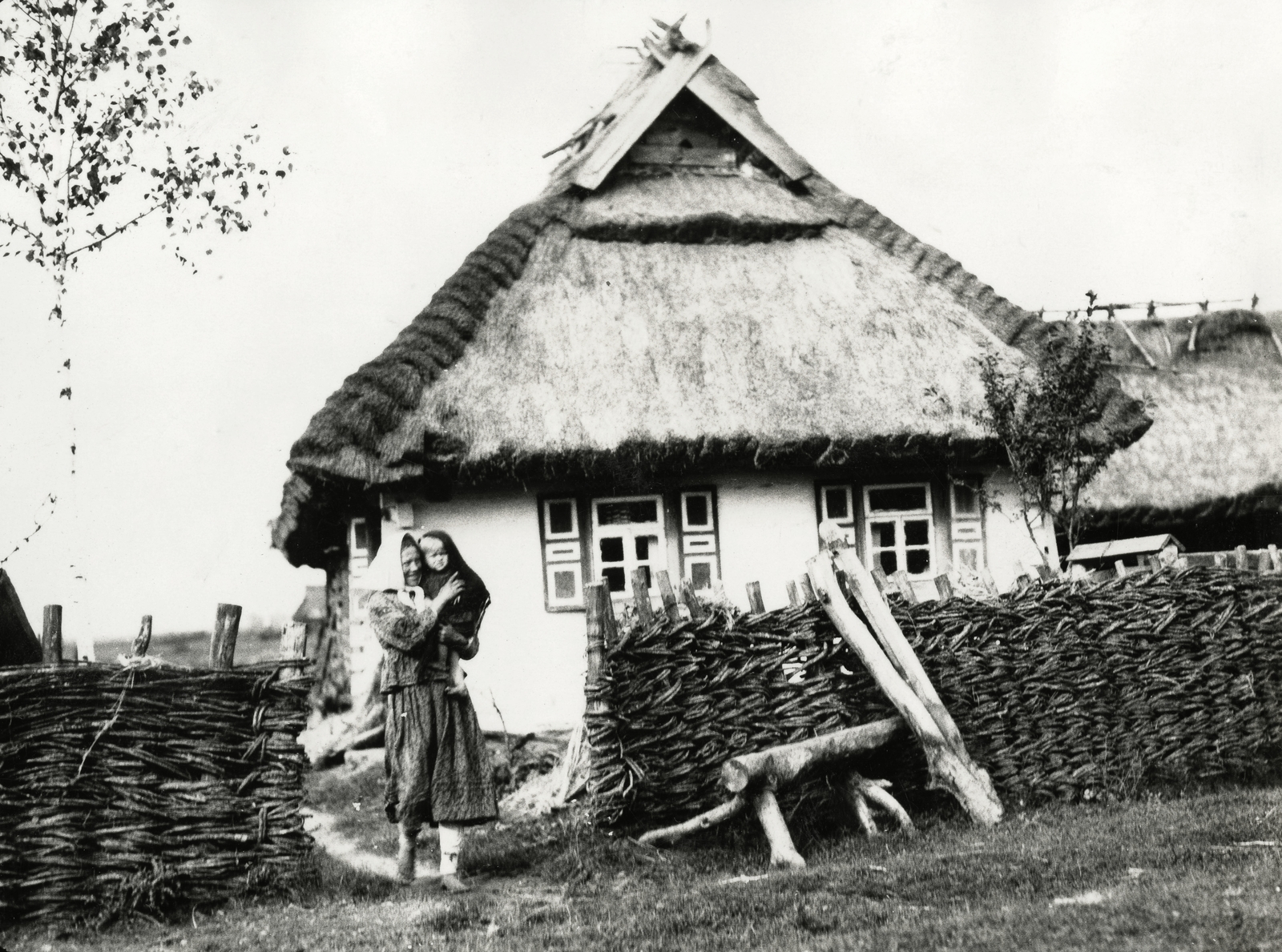 Ukraine, anya és gyermeke a házuk előtt., 1934, UWM Libraries, straw, folk costume, farmhouse, braided fence, Fortepan #260799