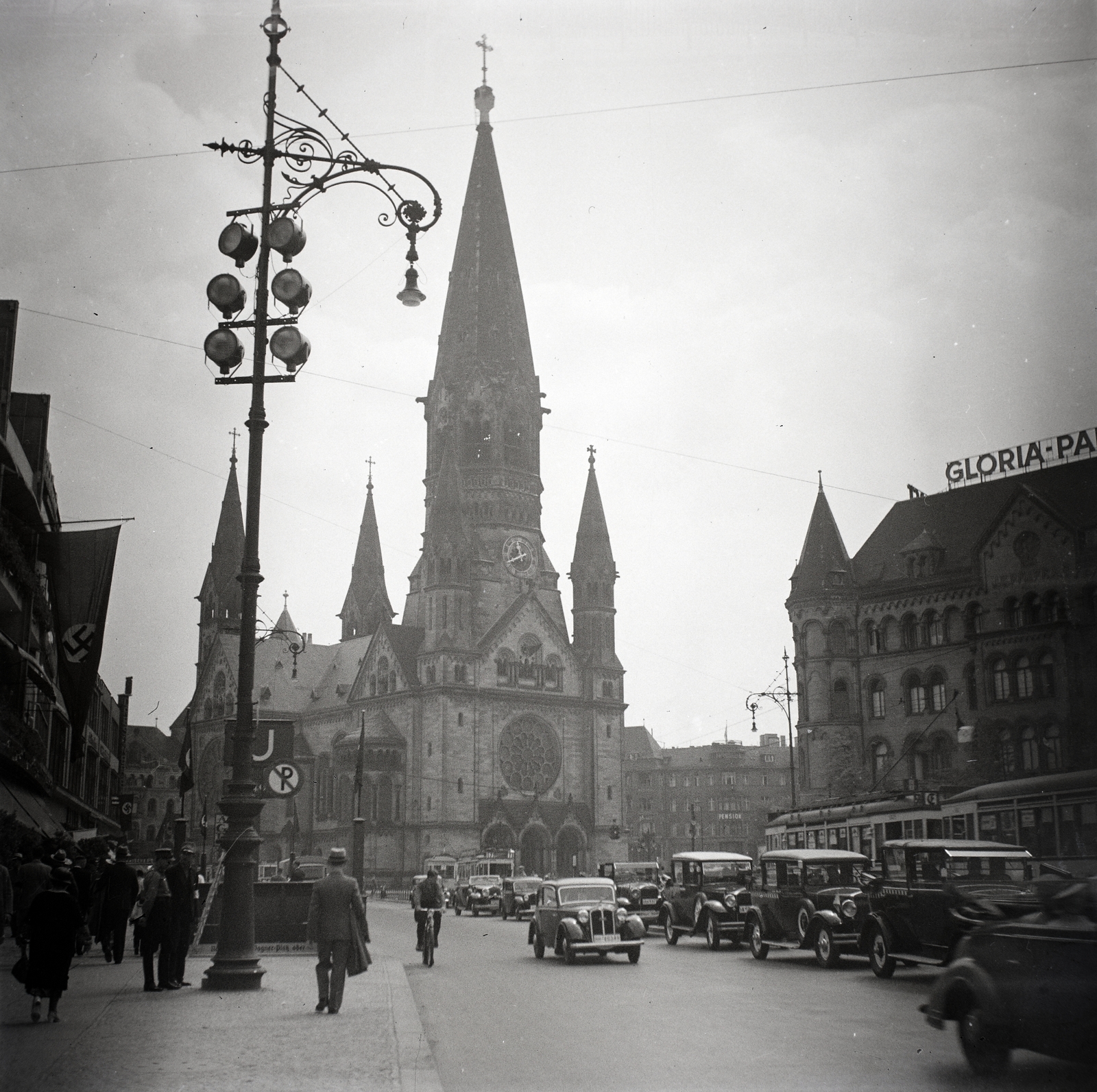 Germany, Berlin, Hardenbergstrasse, szemben a Vilmos császár emléktemplom (Kaiser-Wilhelm-Gedächtnis-Kirche)., 1936, Lőrincze Judit, church, street view, neon sign, swastica, lamp post, automobile, subway, church clock, bicycle, Fortepan #26101