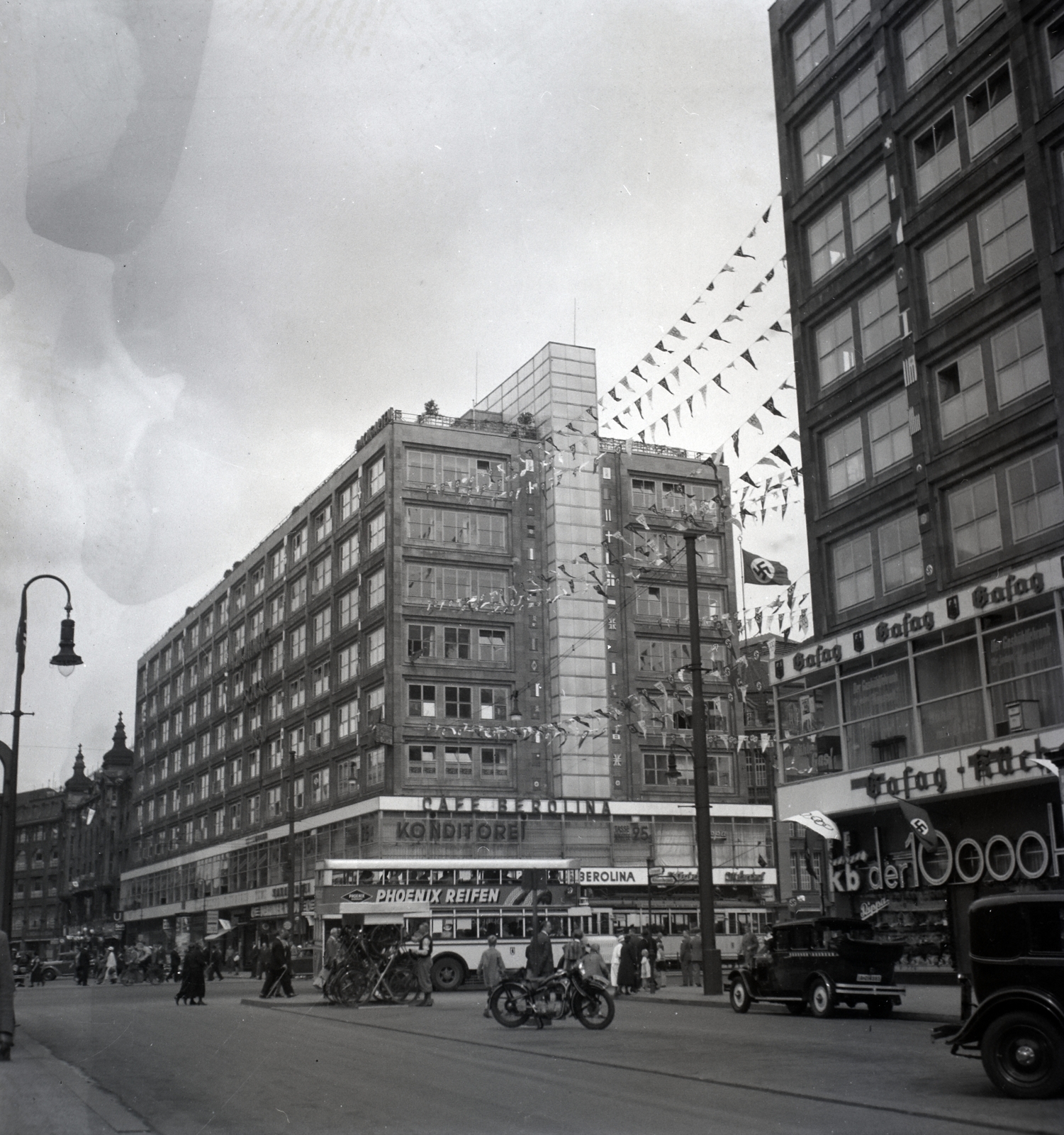 Germany, Berlin, Alexanderplatz, szemben a Berolinahaus., 1936, Lőrincze Judit, motorcycle, neon sign, swastica, pastry shop, coffee house, gas lamp, automobile, modern architecture, bicycle holder, Phoenix Reifen, Peter Behrens-design, Fortepan #26116