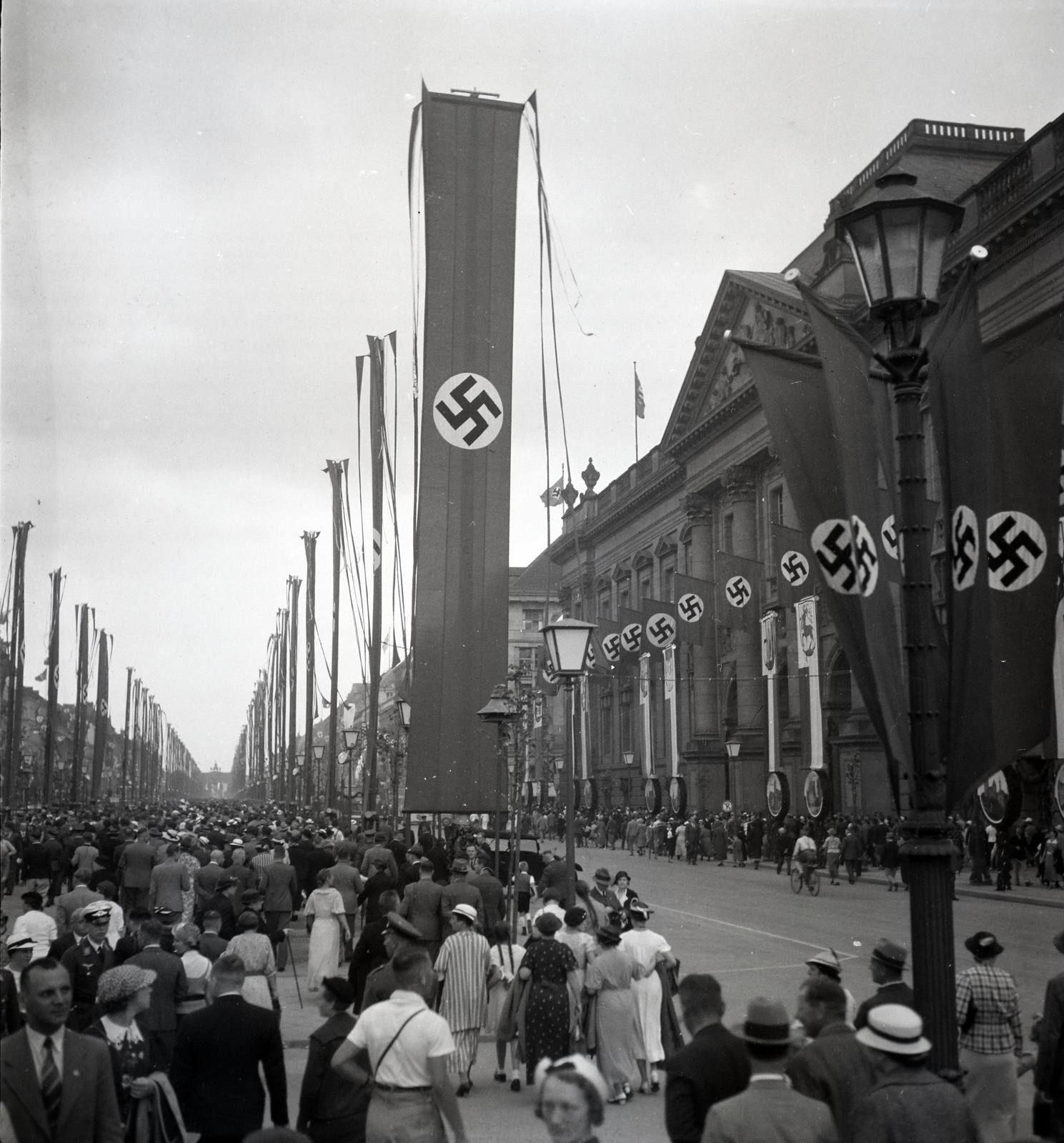 Germany, Berlin, Unter den Linden, jobbra a Staatsbibliothek, háttérben a Brandenburgi kapu., 1936, Lőrincze Judit, flag, swastica, Olympics, bunting, bicycle, Fortepan #26120