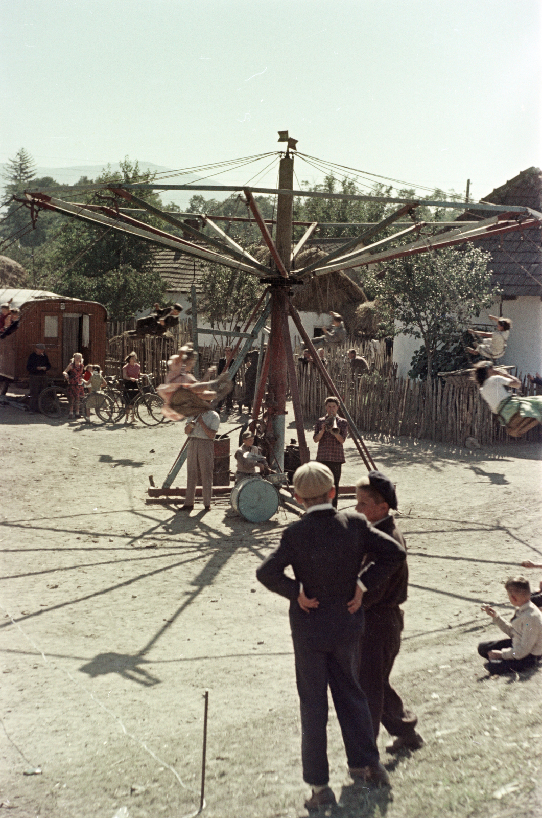 Magyarország, Tornyosnémeti, búcsú a Fő utcán a Szűz Mária neve-templomnál., 1954, Faragó György, színes, körhinta, dobos, svájcisapka, lakókocsi, léckerítés, kerékpár, fúvószenekar, Fortepan #261548