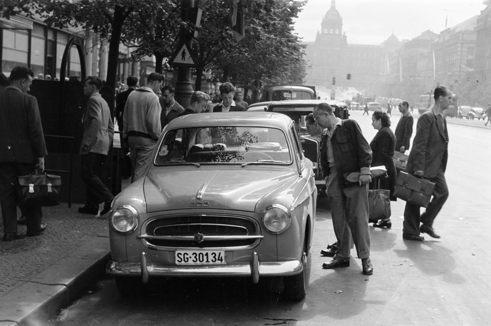 Czech Republik, Prague, Vencel tér (Václavské námestí), szemben a Nemzeti Múzeum sziluettje látható., 1956, Faragó György, men, street view, automobile, number plate, briefcase, peeking, Czechoslovakia, Fortepan #261582