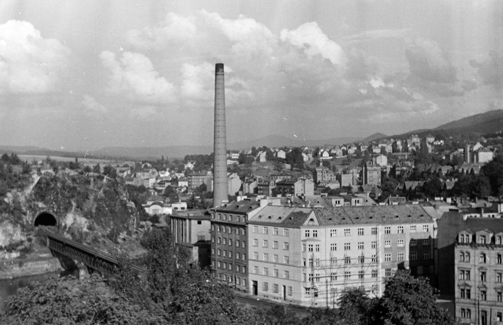 Czech Republik, Karlovy Vary, látkép a vasútállomás felől, szemben a nábřeží Jana Palacha - ulica Foersterova sarok, balra az Ohře folyó felett az alagút felé vezető vasúti híd., 1956, Faragó György, picture, chimney, tenement house, railway bridge, tunnel, Czechoslovakia, Fortepan #261602