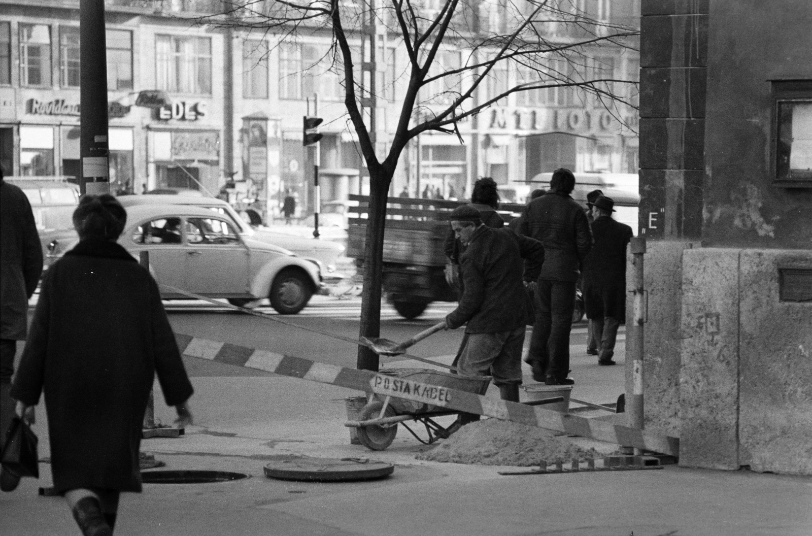 Magyarország, Budapest VII., Deák Ferenc tér az evangélikus templom előtt, háttérben a Károly (Tanács) körút melletti Madách házak üzletsora látható., 1972, Gyulai Gaál Krisztián, Budapest, utcakép, munkás, talicska, lapát, útjavítás, Fortepan #262670