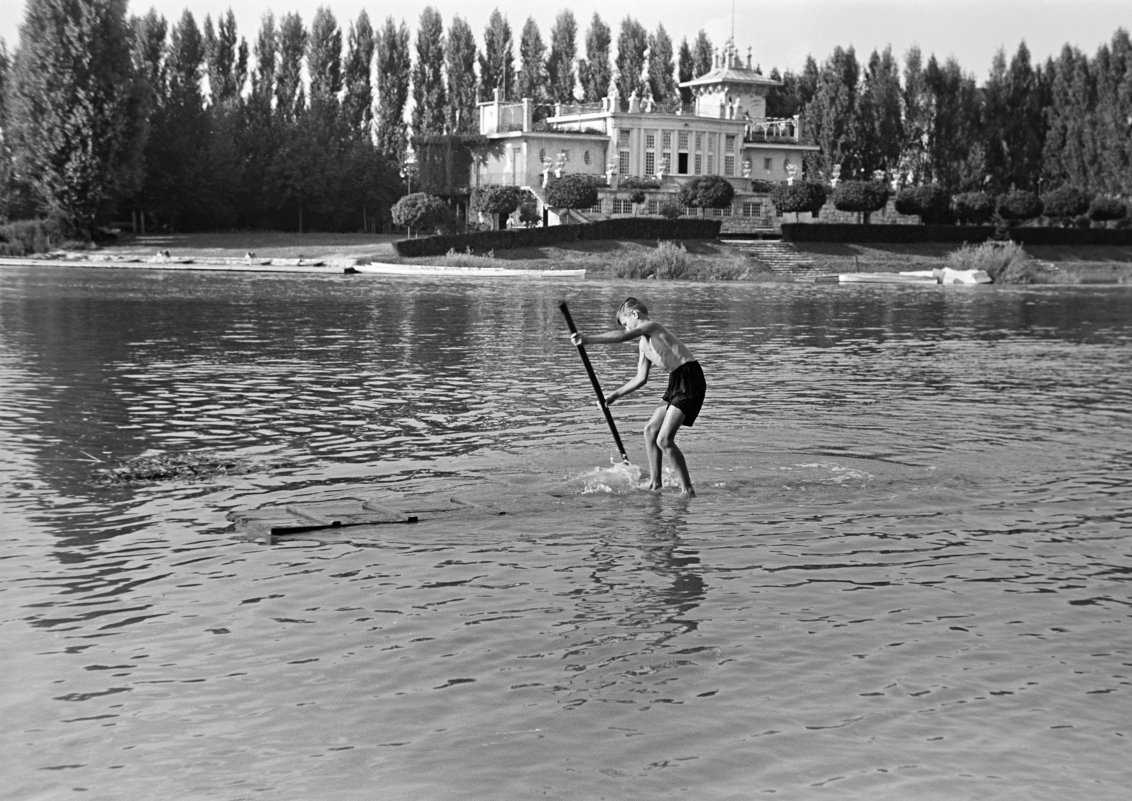 Magyarország, Győr, Mosoni-Duna, pallón evező fiú. Túlparton Révfalu. a Győri Torna és Evezősegylet (GyTE) csónakháza., 1938, Nagy István, Nagy József, tutaj, vízpart, evezés, Best of, Fortepan #264205