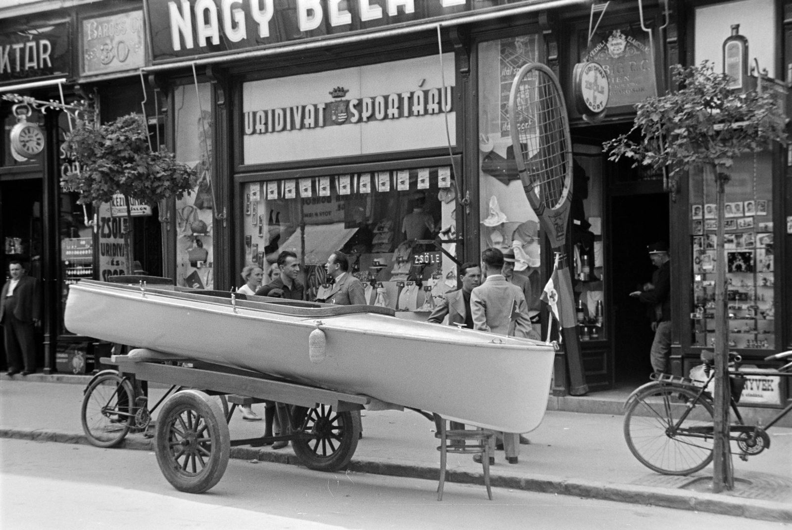Hungary, Győr, Baross Gábor út 30., a felvétel Nagy Béla uridivat és sportáru üzlete előtt készült., 1938, Nagy István, Best of, handbarrow, store display, watch, boat, bicycle, tennis rackets, sporting goods, Fortepan #264212