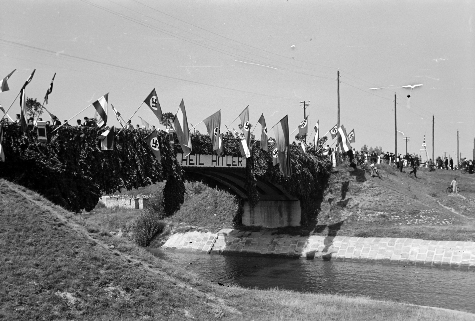 Magyarország, Győr, a diadalkapuként feldíszített Iparcsatorna feletti betonhíd, a Hitlerjugend westfáliai tengerészalakulatának fogadásakor. A felvétel 1939. augusztus 20-án készült., 1939, Nagy István, Nagy József, Best of, zászló, felirat, horogkereszt, nácizmus, Fortepan #264339