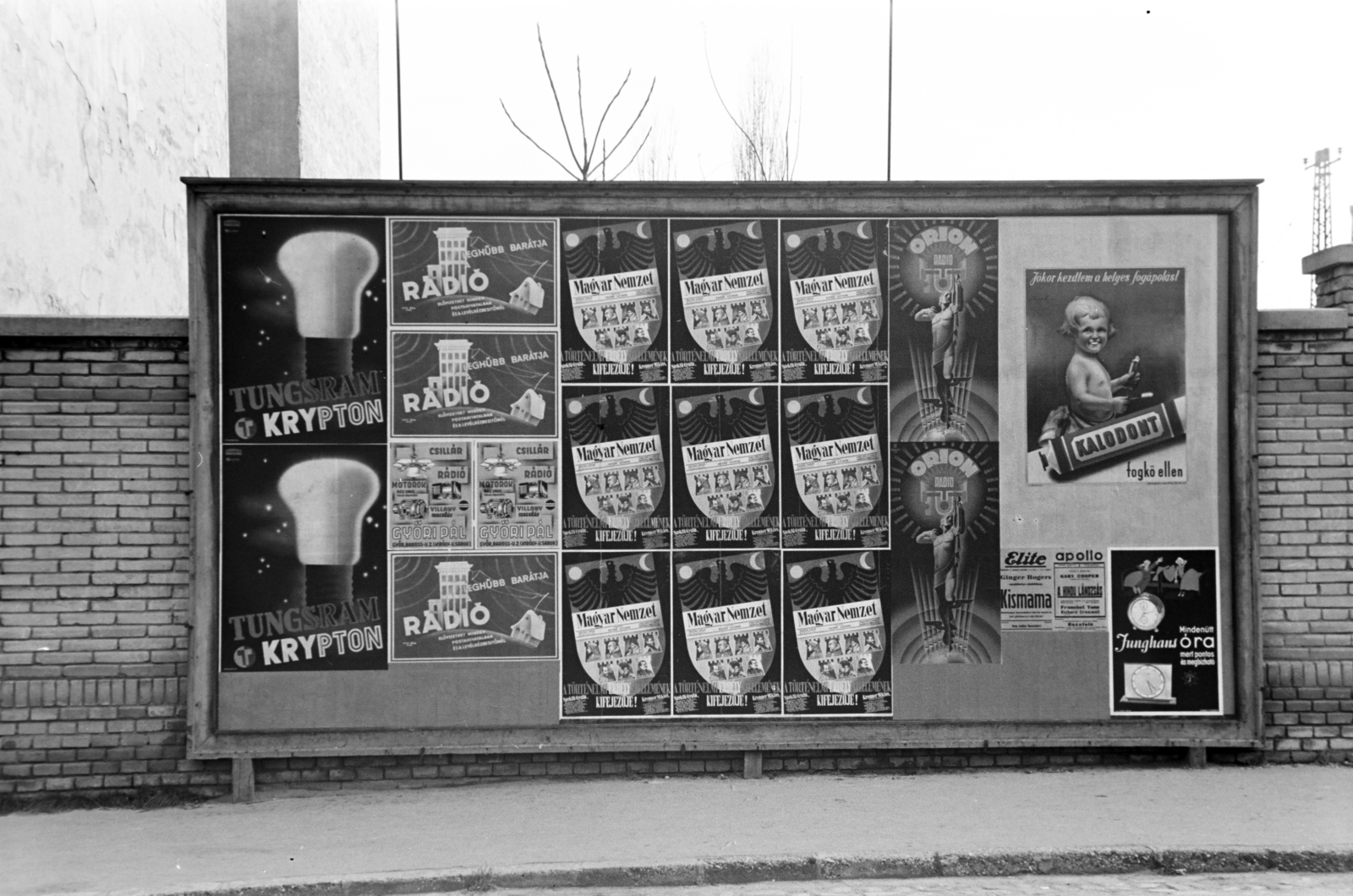 Hungary, Győr, reklámtábla a Bisinger József sétány 8-as számú beépítetlen telek kerítése előtt., 1940, Nagy István, poster, radio broadcasting, Orion-brand, Tungsram-brand, Fortepan #264391