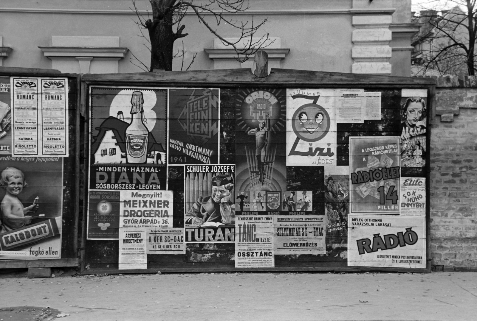 Hungary, Győr, reklámtáblák a Bajcsy-Zsilinszky Endre (Andrássy) út - Czuczor Gergely (Alsó-Duna) utca sarkán álló, egykori Bisinger óvoda helyén épült Osztrák-Magyar Bank palotájának kerítése előtt., 1940, Nagy István, Best of, poster, Telefunken-brand, Diana rubbing alcohol, stationery, Orion-brand, radio broadcasting, newspaper, Fortepan #264407