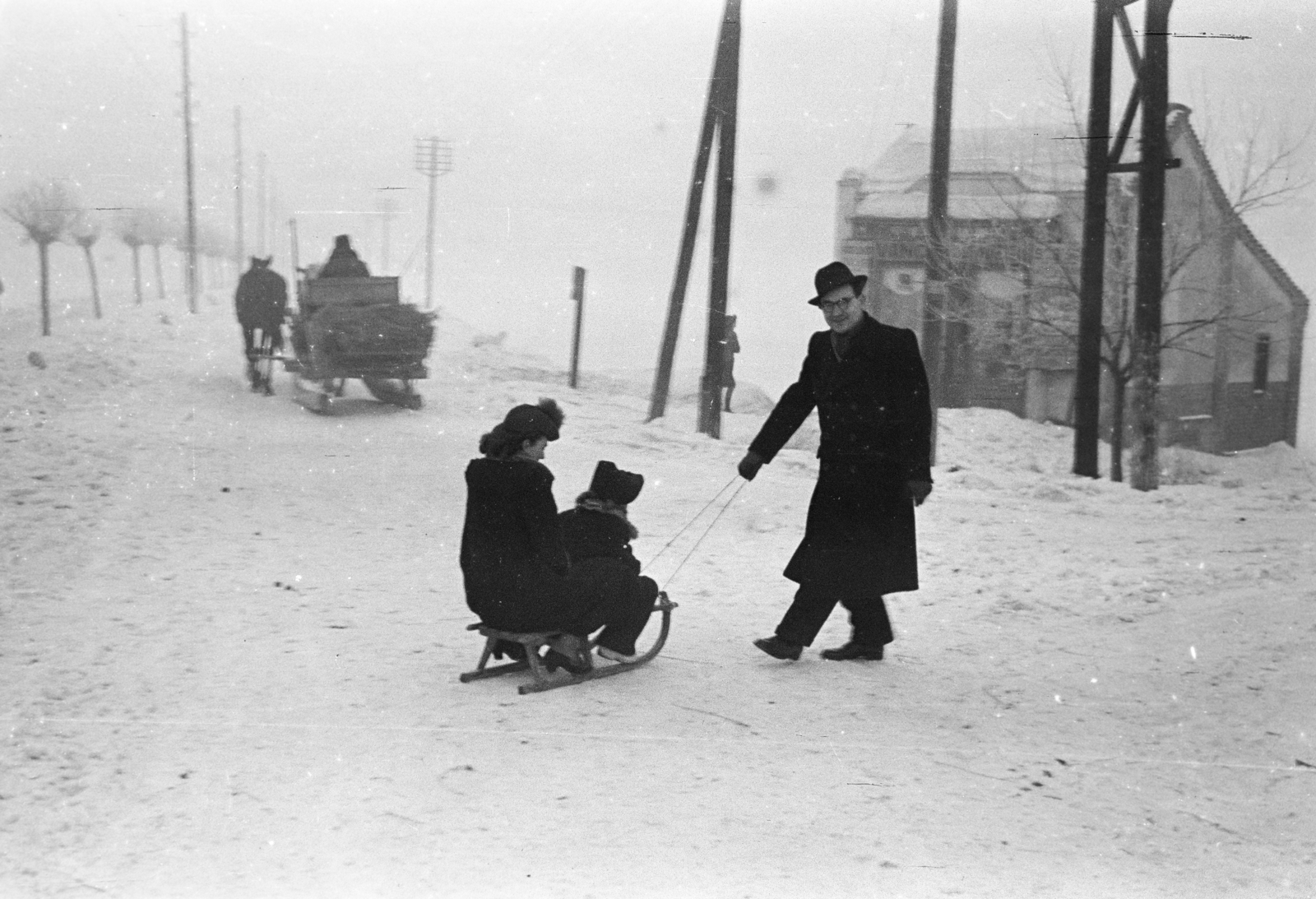 Magyarország, Dombóvár, Újdombóvár (ekkor önálló, ma a város része), háttérben Vancsa Antal vegyesboltja., 1947, Horváth József, szánkó, hó, lovaskocsi, család, gyerek, Fortepan #264849