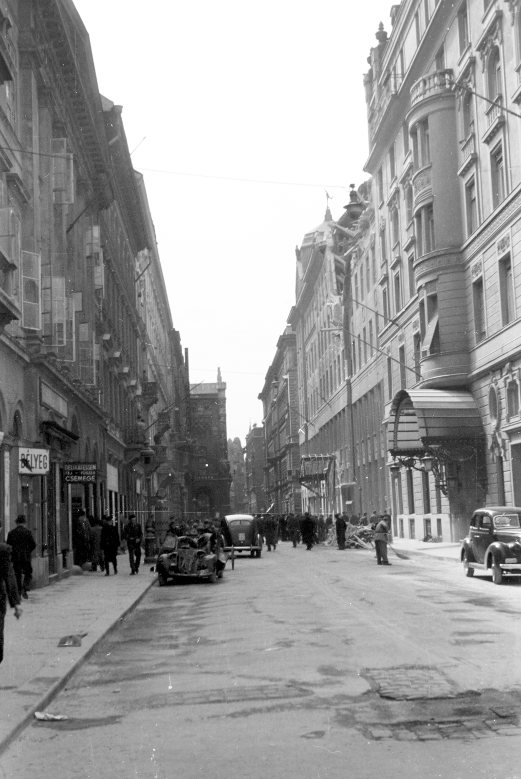 Magyarország, Budapest V., az Apáczai Csere János (Mária Valéria) utca Eötvös térről - Vigadó tér közötti szakasza bombatámadás után. Jobbra a Dunapalota / Ritz szálló, mellette az új Llloyd-palota., 1944, Horváth József, épületkár, romeltakarítás, járműroncs, taxiállomás, munkaszolgálatos, Budapest, Fortepan #265142
