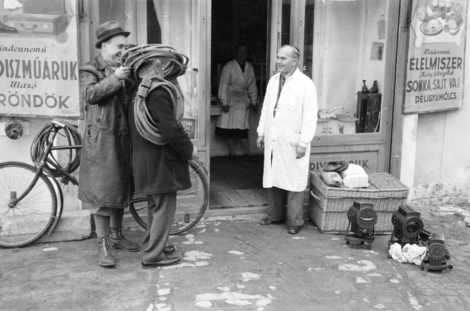 Hungary, Dombóvár, Újdombóvár (ekkor önálló, ma a város része), a felvétel Vancsa Antal vegyesboltja előtt készült., 1940, Horváth József, cloak, store display, bicycle, leather jacket, extension cord, wicker crate, Fortepan #265365