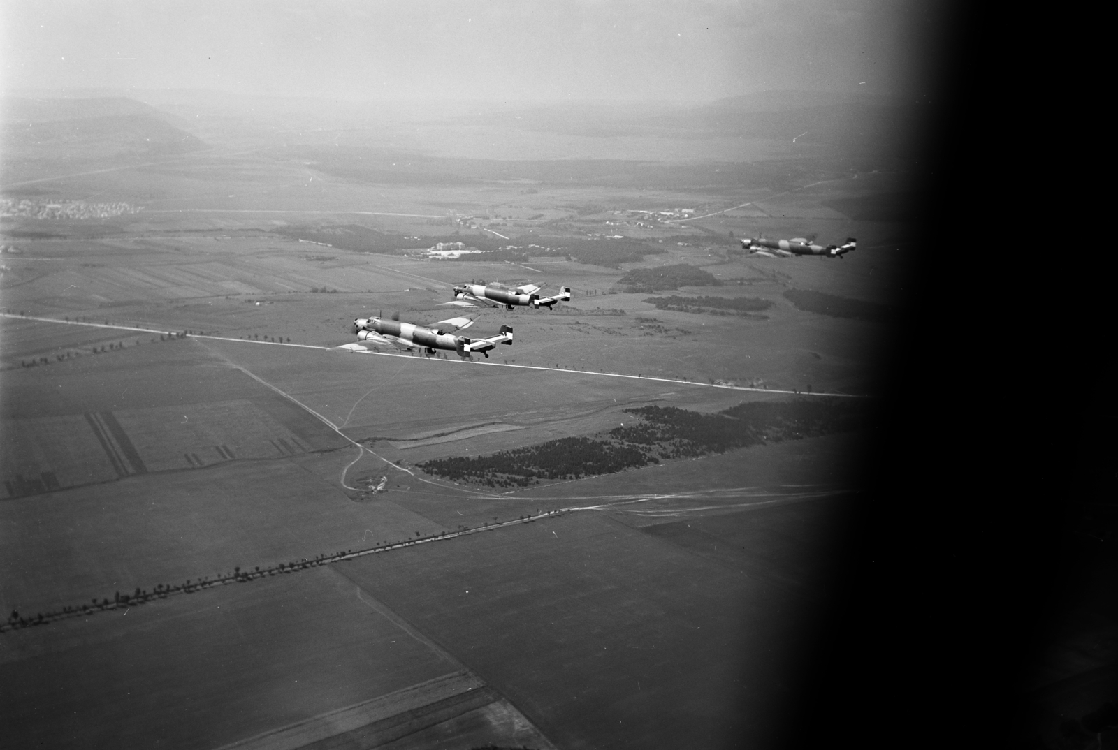 Hungary, Veszprém, légifotó, a város fölé keleti irányból érkező, a Magyar Királyi Honvéd Légierő Junkers Ju 86 típusú repülőgépeiről. Középen keresztbe a 82-es főút, balra a Dózsaváros széle látszik. Jobbra fönt a Jutas repülőtérre tartó út, lent átlósan a 8-as és 82-es főutakat összekötő fasorral szegélyezett földút., 1938, Horváth József, Best of, airplane, Junkers-brand, Royal Hungarian Air Force, aerial photo, Fortepan #265999