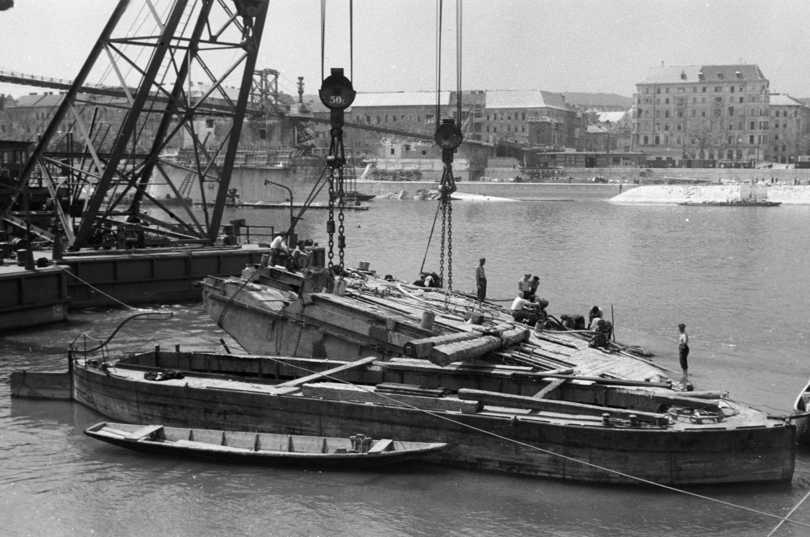 Magyarország, Margitsziget, Budapest II., a lerombolt Margit híd újjáépítésén dolgozó Ady Endre és József Attila úszódaru, a felvétel a Margitsziget partjáról készült. Háttérben a híd pillérein épült, fajármokra szerelt, közművezetékeket is hordozó kábelhíd látható., 1947, Vízkelety László, Budapest, hajódaru, Fortepan #266142