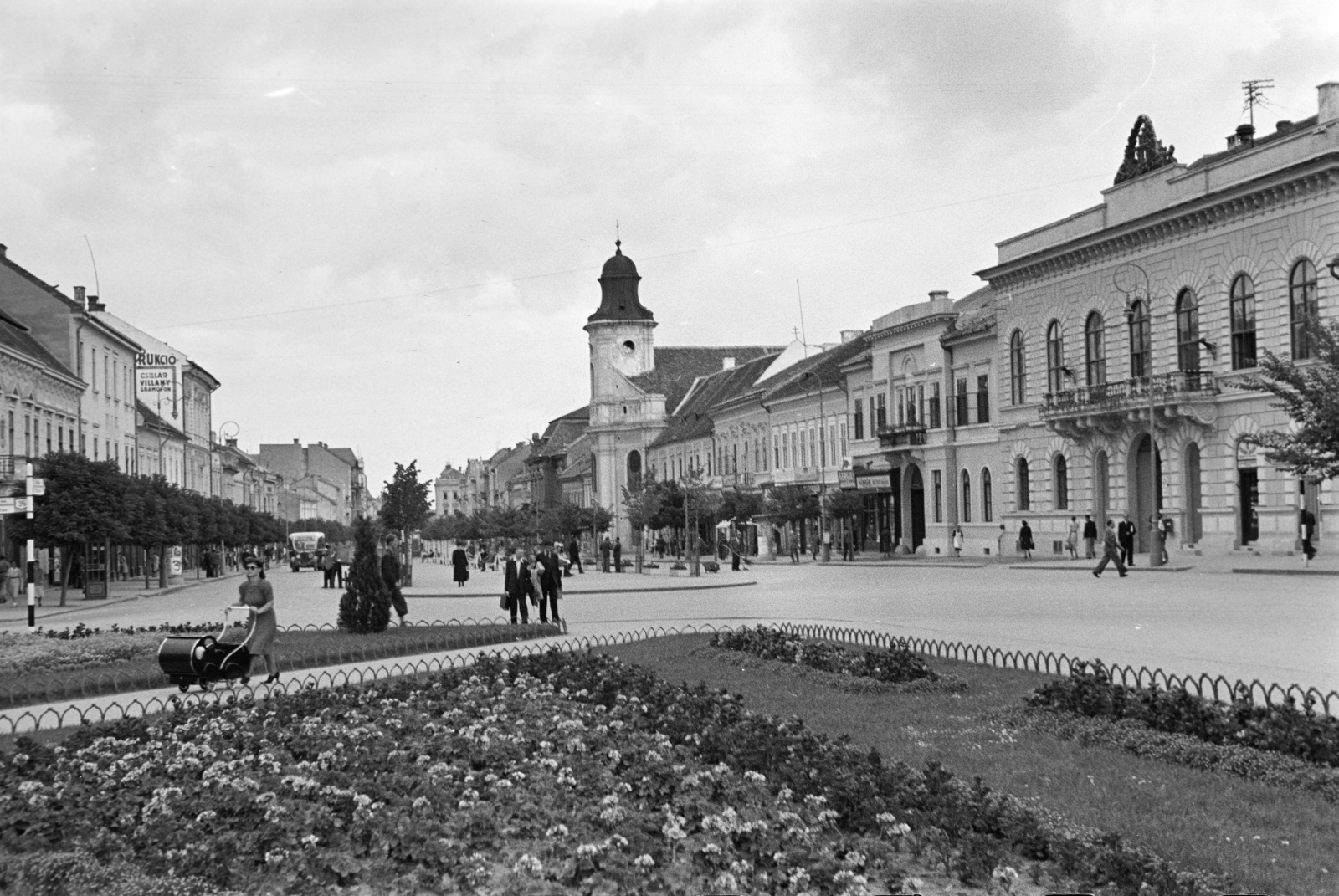 Romania,Transylvania, Cluj-Napoca, Mátyás király tér a Deák Ferenc utca (Bulevardul Eroilor) felé nézve. Középen a görög katolikus templom., 1942, Ábrahám Katalin és László, baby carriage, flower bed, Fortepan #266626